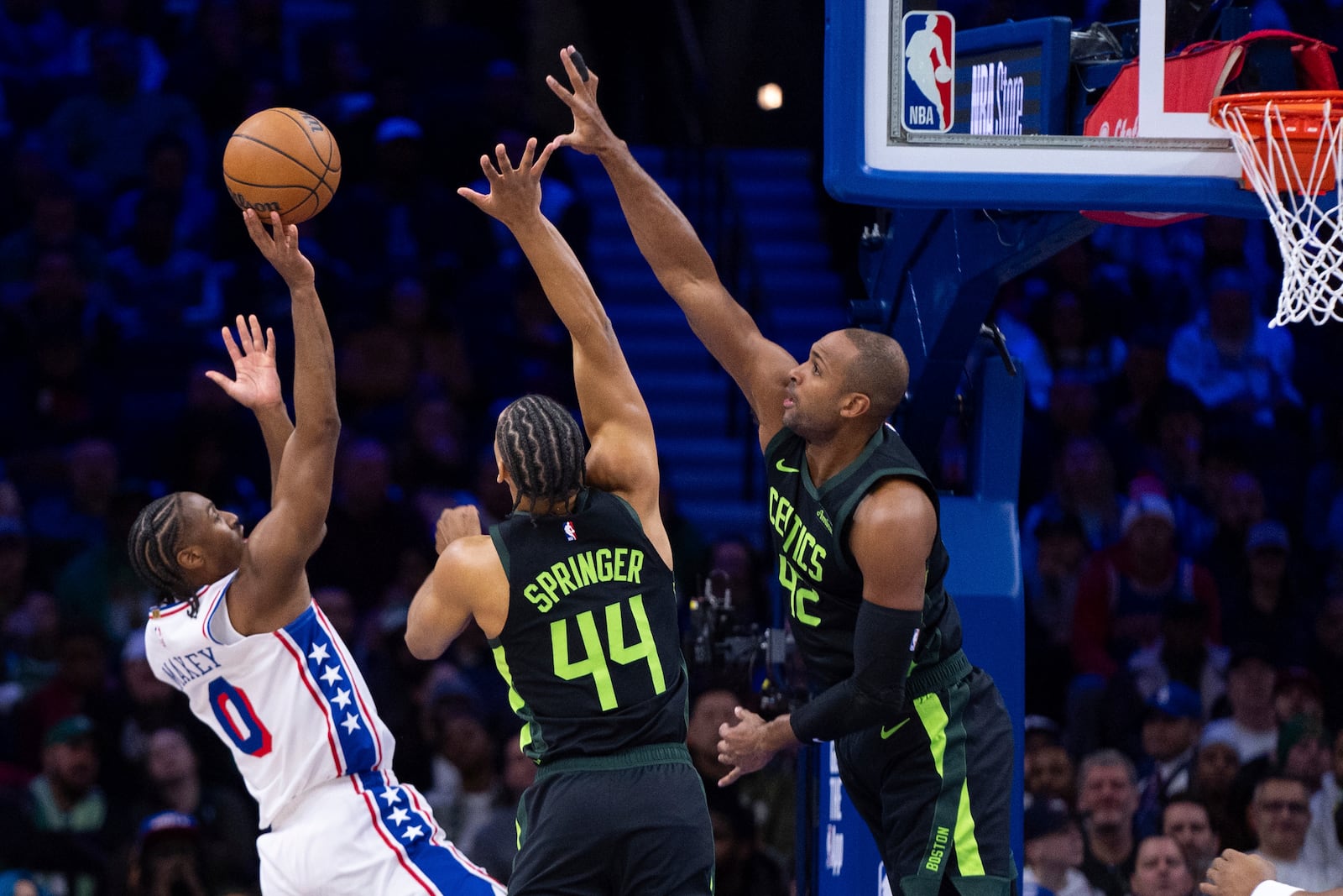 Philadelphia 76ers' Tyrese Maxey, left, shoots the ball with Boston Celtics' Jaden Springer, center, and Al Horford, right, defending during the first half of an NBA basketball game, Sunday, Feb. 2, 2025, in Philadelphia. (AP Photo/Chris Szagola)