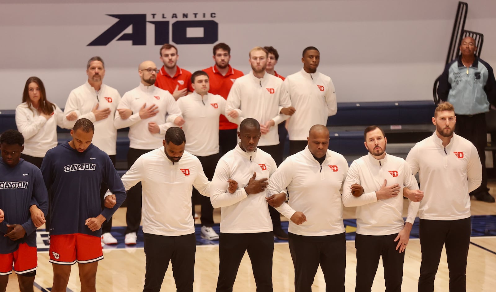 Dayton coaches stand for the national anthem before a game against George Washington on Saturday, Jan. 4, 2025, at the Charles E. Smith Center in Washington, D.C. David Jablonski/Staff