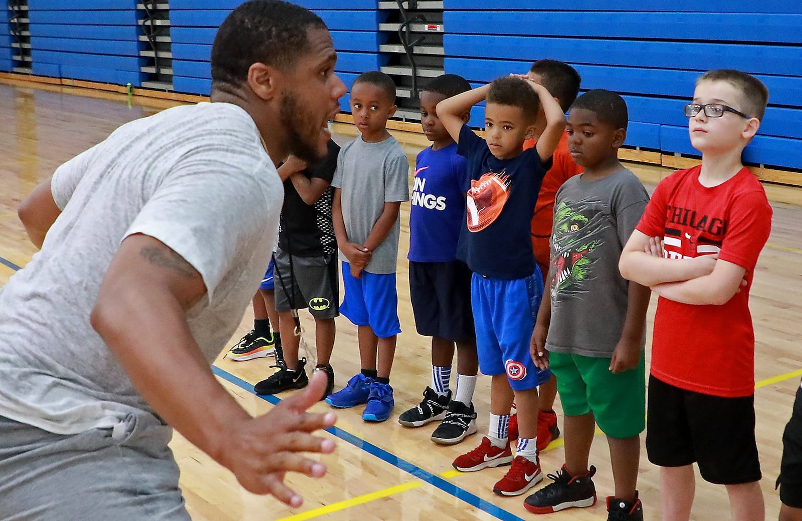 Nate Miller, a Springfield South graduate and professional basketball player, talks to young players about defense during a Springfield Youth Basketball Camp at Springfield High School. BILL LACKEY/STAFF