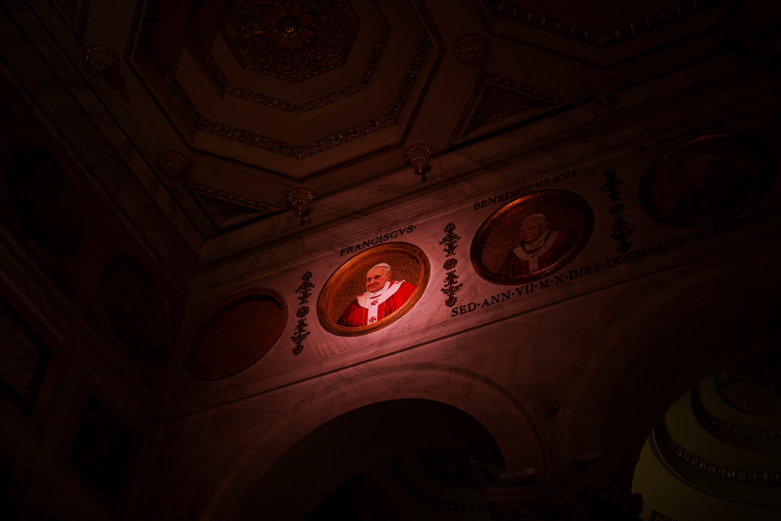 A light illuminates a polychrome mosaic portrait of Pope Francis placed on the frieze of St. Paul's Outside The Walls Basilica in Rome, Wednesday, Feb. 26, 2025. (AP Photo/Bernat Armangue)