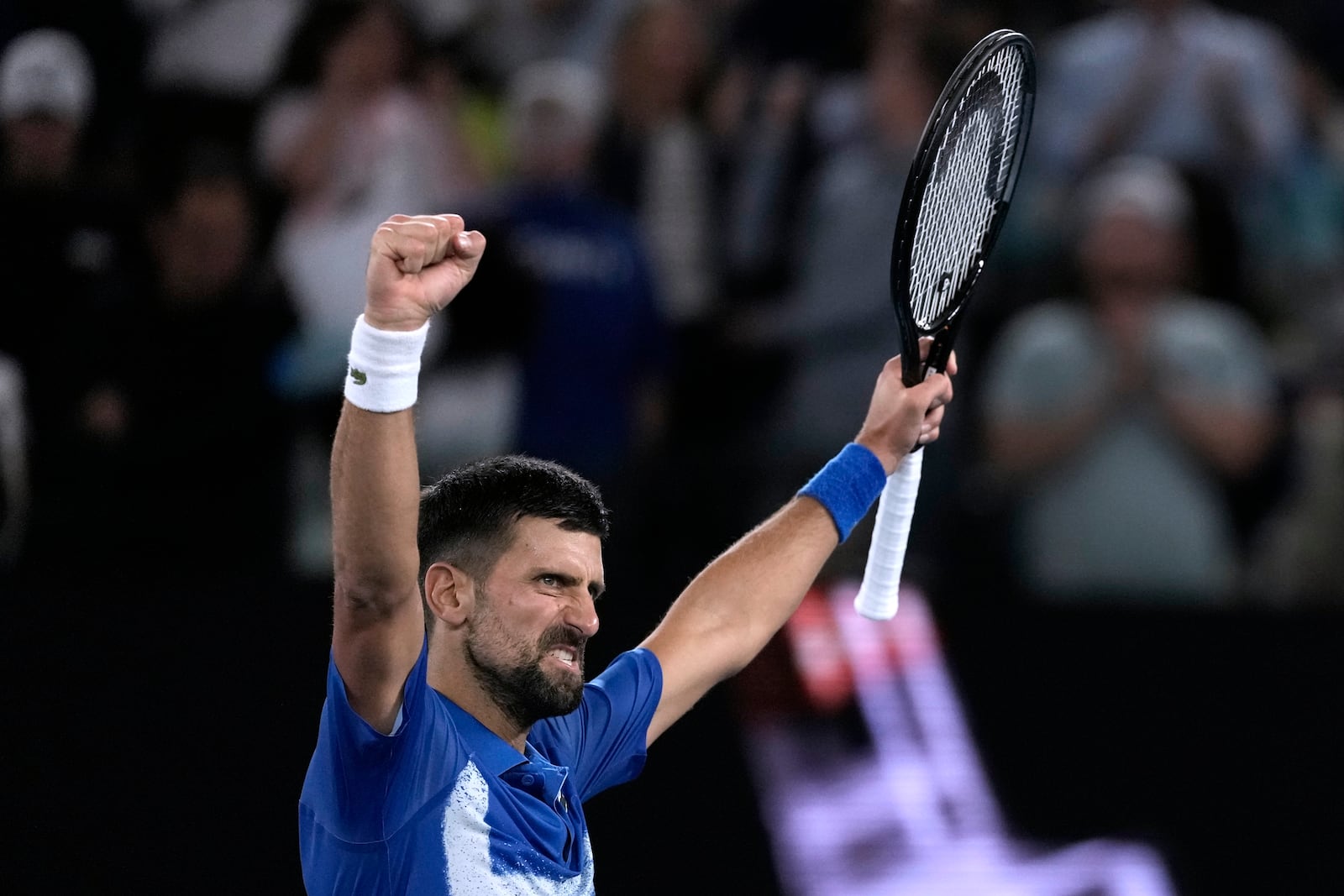 Novak Djokovic of Serbia celebrates after defeating Carlos Alcaraz of Spain in their quarterfinal match at the Australian Open tennis championship in Melbourne, Australia, Wednesday, Jan. 22, 2025. (AP Photo/Ng Han Guan)