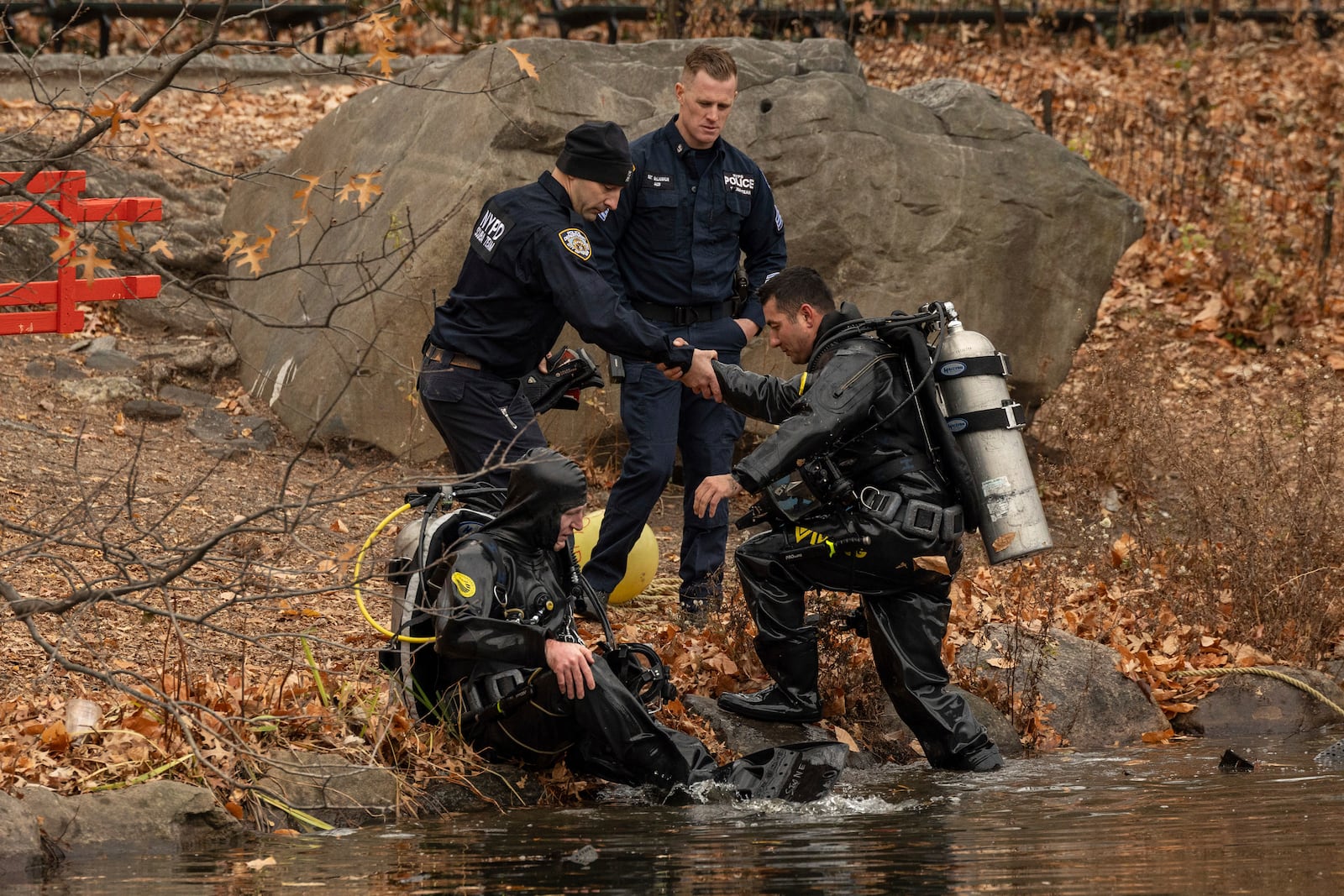 NYPD officers in diving suits sit after searching the lake in the Central Park, Monday, Dec. 9, 2024, in New York. (AP Photo/Yuki Iwamura)