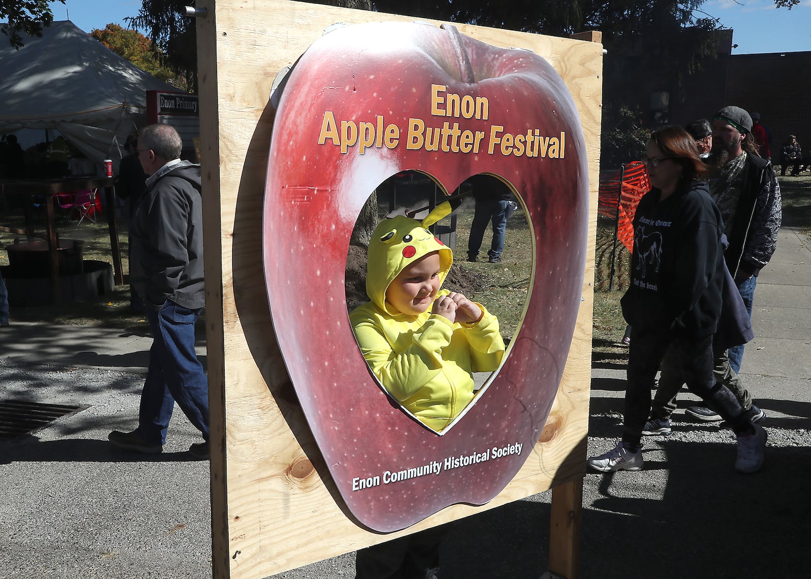 Damen Flanders poses in a giant apple for his mother Saturday, Oct. 8, 2022 at the Enon Apple Butter Festival. BILL LACKEY/STAFF