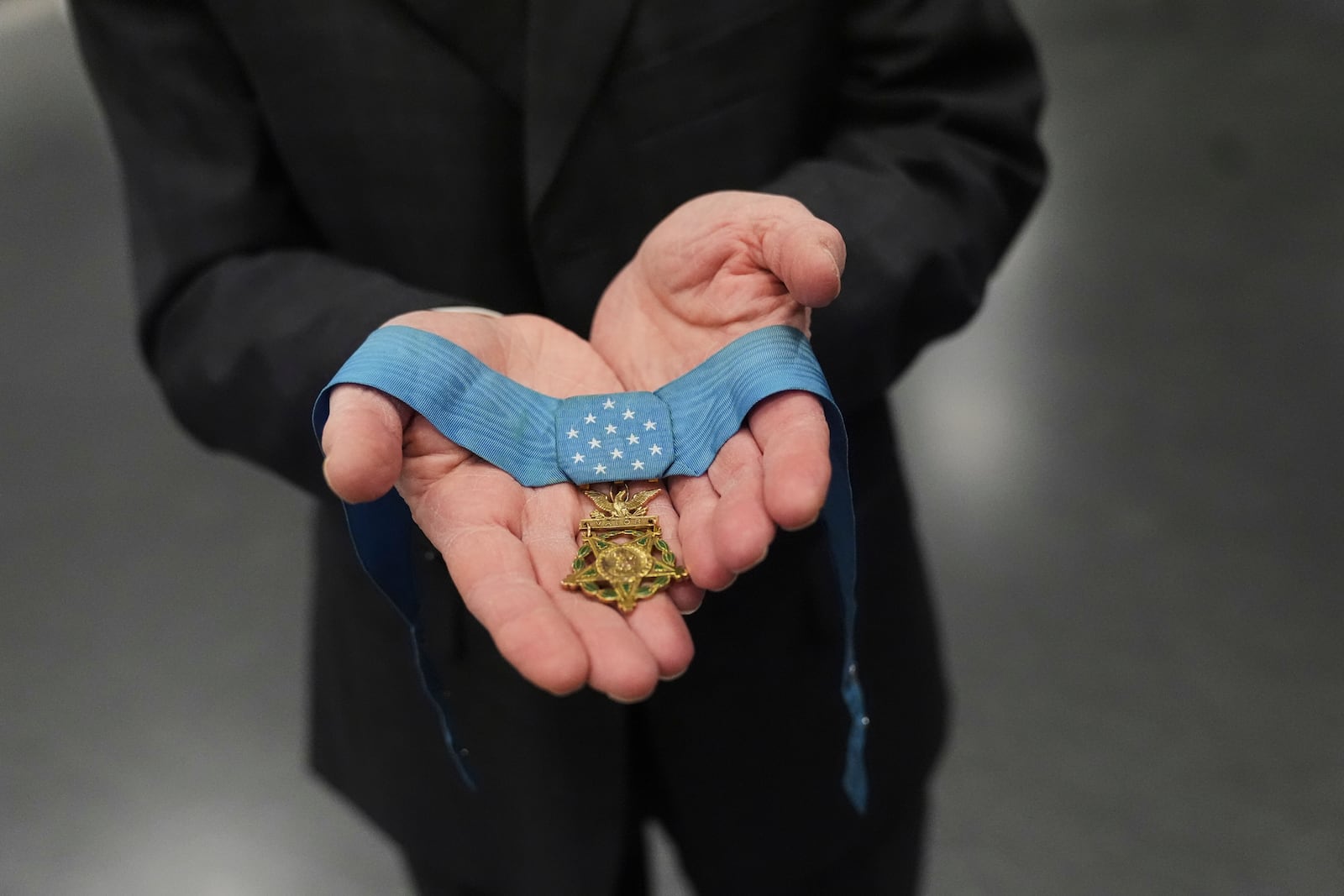 Jack Jacobs, a retired U.S. Army colonel who was awarded the Medal of Honor for his actions during the Vietnam War, poses for a photo holding the medal in his hands while being interviewed at the National Medal of Honor Museum in Arlington, Texas, Thursday, March 13, 2025. (AP Photo/Tony Gutierrez)