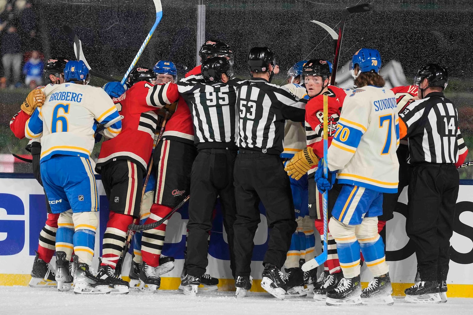 Officials break up a fight between the St. Louis Blues and Chicago Blackhawks during the second period of the NHL Winter Classic outdoor hockey game at Wrigley Field, Tuesday, Dec. 31, 2024, in Chicago. (AP Photo/Erin Hooley)