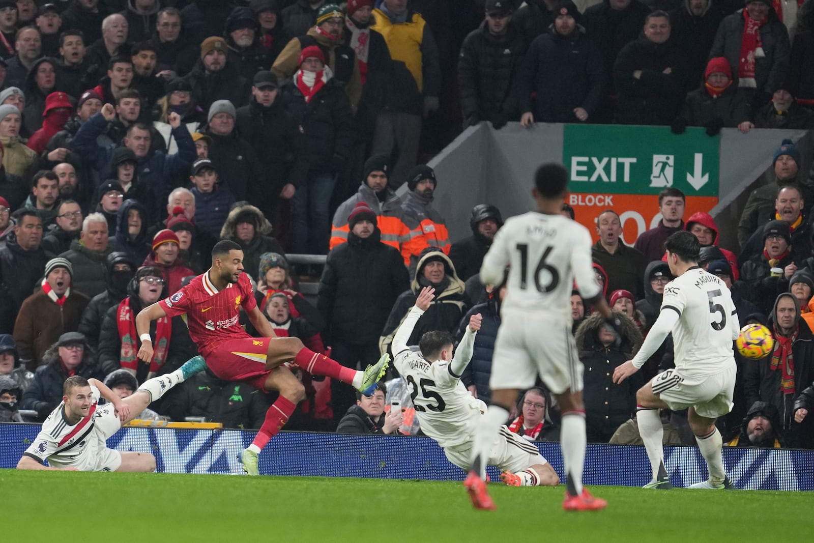 Liverpool's Cody Gakpo, left, scores his side's first goal against Manchester United during the English Premier League soccer match at the Anfield stadium in Liverpool, England, Sunday, Jan. 5, 2025. (AP Photo/Jon Super)