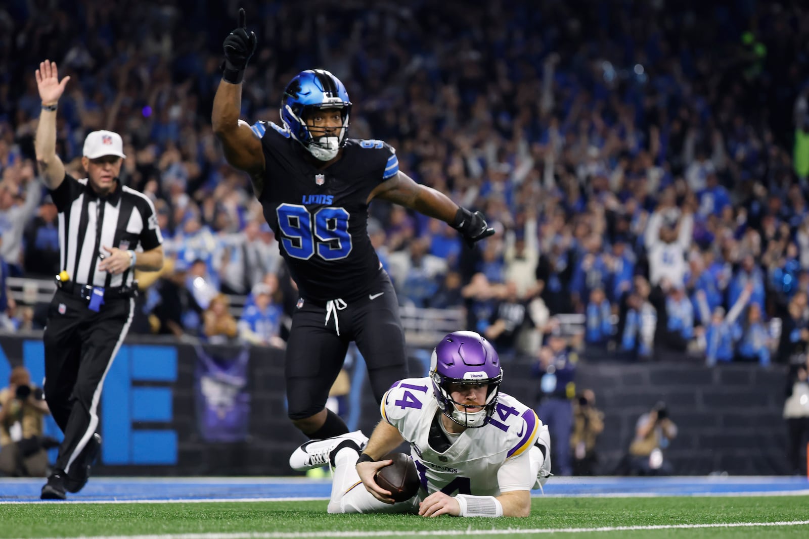 Minnesota Vikings quarterback Sam Darnold (14) is sacked by Detroit Lions defensive end Za'Darius Smith (99) during the first half of an NFL football game Sunday, Jan. 5, 2025, in Detroit. (AP Photo/Rey Del Rio)