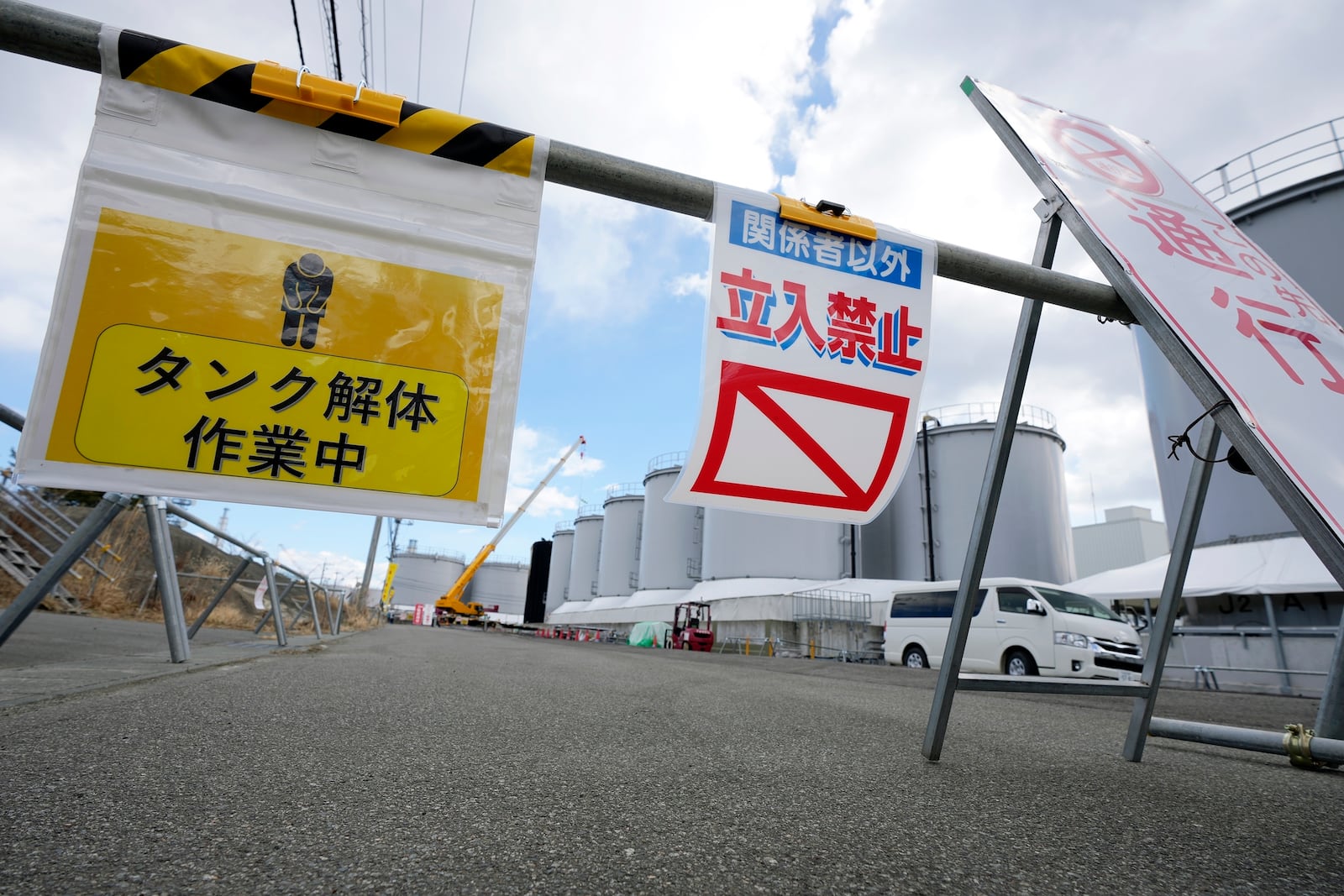 Workers carry out the dismantling work of the treated water tanks at the Fukushima Daiichi nuclear power plant, operated by Tokyo Electric Power Company Holdings (TEPCO), in Okuma town, northeastern Japan on Monday Feb. 20, 2025. (AP Photo/Eugene Hoshiko)