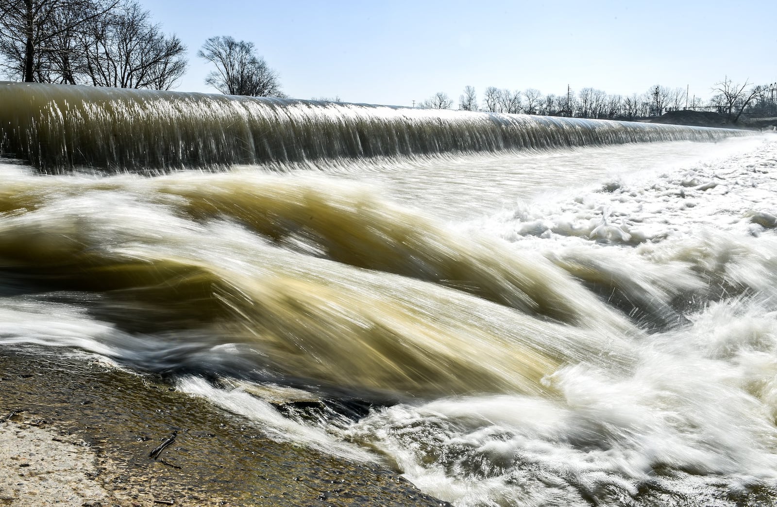 Water flows over the low level dam on the Great Miami River at Combs Park in Hamilton. 