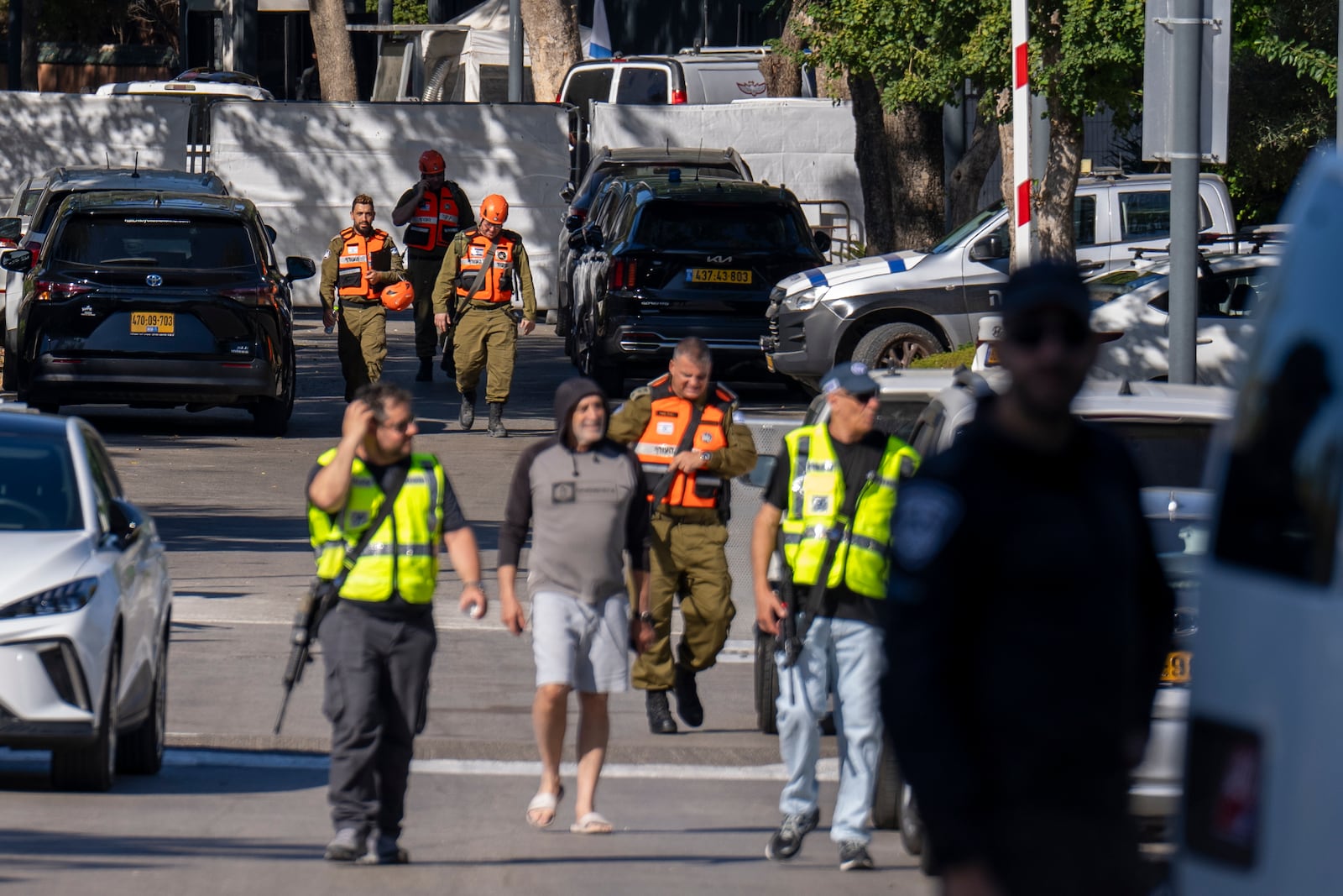 Officers from the Israeli Home Front Command military unit walk on a road near where Israel's government says a drone launched toward Israeli Prime Minister Benjamin Netanyahu's house in Caesarea, Israel, Saturday, Oct. 19, 2024. (AP Photo/Ariel Schalit)