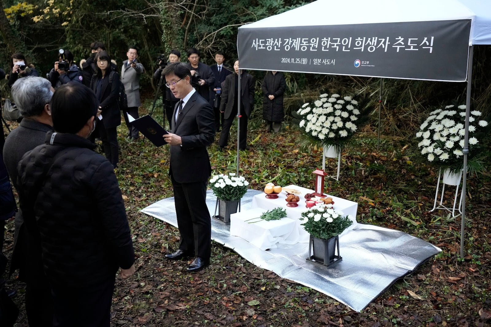 South Korean Ambassador to Japan Park Cheol-hee, center, delivers a speech as relatives of Korean victims and South Korean officials hold a memorial service in Sado, Niigata prefecture, Japan, Monday, Nov. 25, 2024. (AP Photo/Eugene Hoshiko)