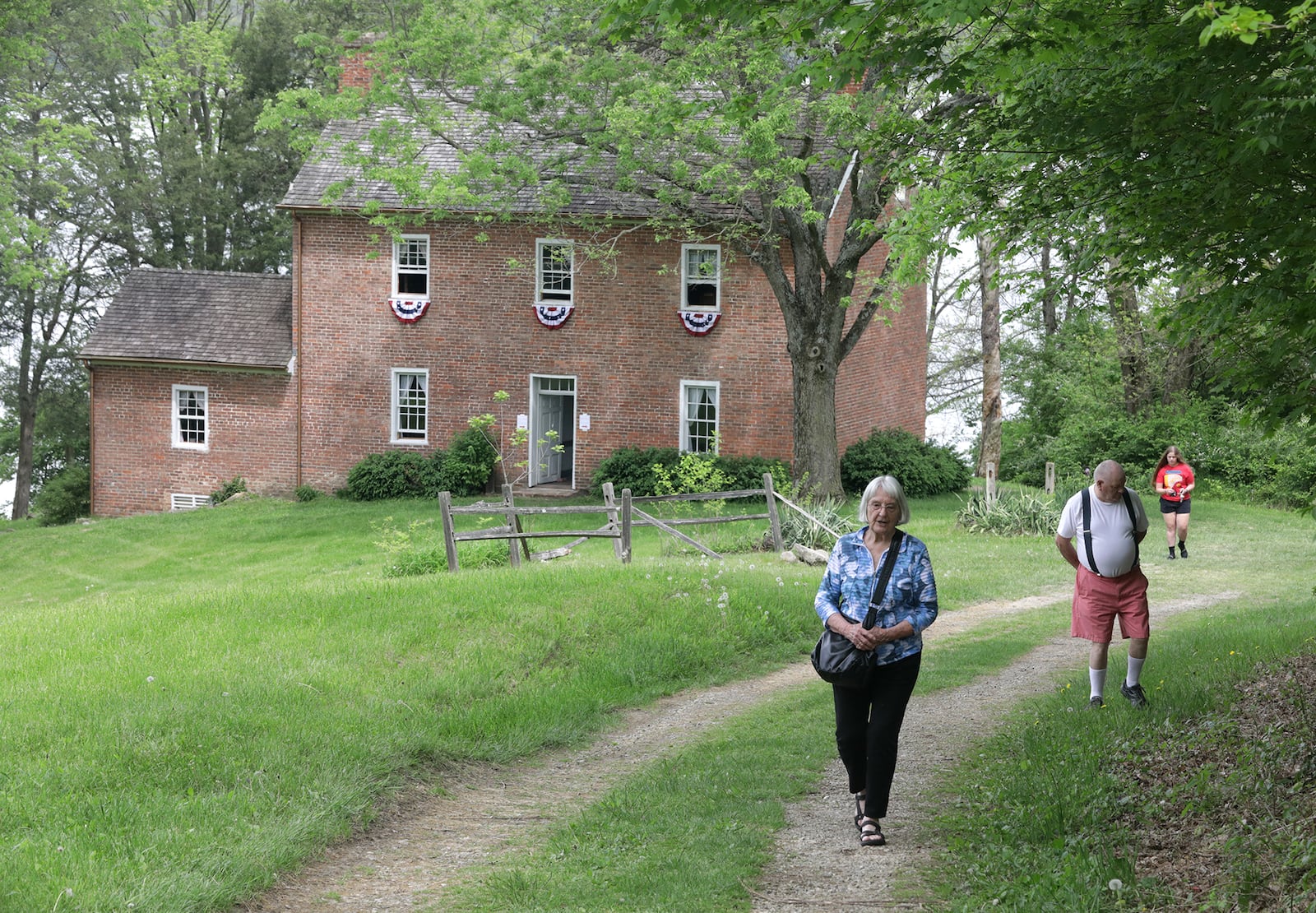 Flossy Hulsizer and her husband, Bob, make their way up the long drive leading to the Crabill Homestead during an open house Saturday, May 14, 2022. The homestead, at Buck Creek State Park is again under the management of the Clark County Historical Society, the organization that originally led the restoration of the 1820s home. BILL LACKEY/STAFF