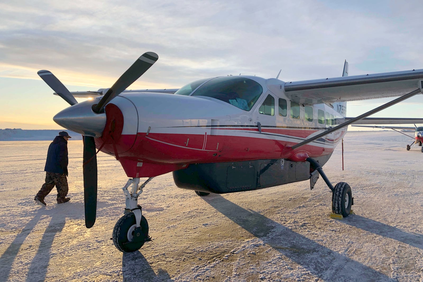 FILE - This Jan. 18, 2020, photo shows people preparing to get on a Ravn Connect airplane at the airport in Bethel, Alaska, for a flight to Toksook Bay. (AP Photo/Mark Thiessen, File)