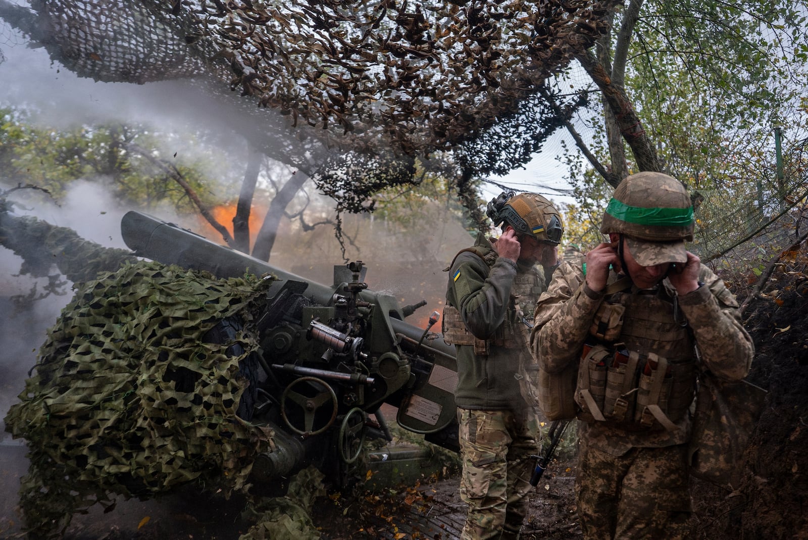 Ukrainian servicemen of Khartia brigade fire D-30 Howitzer towards Russian positions in Kharkiv region, Ukraine, Wednesday, Oct. 16, 2024. (AP Photo/Alex Babenko)