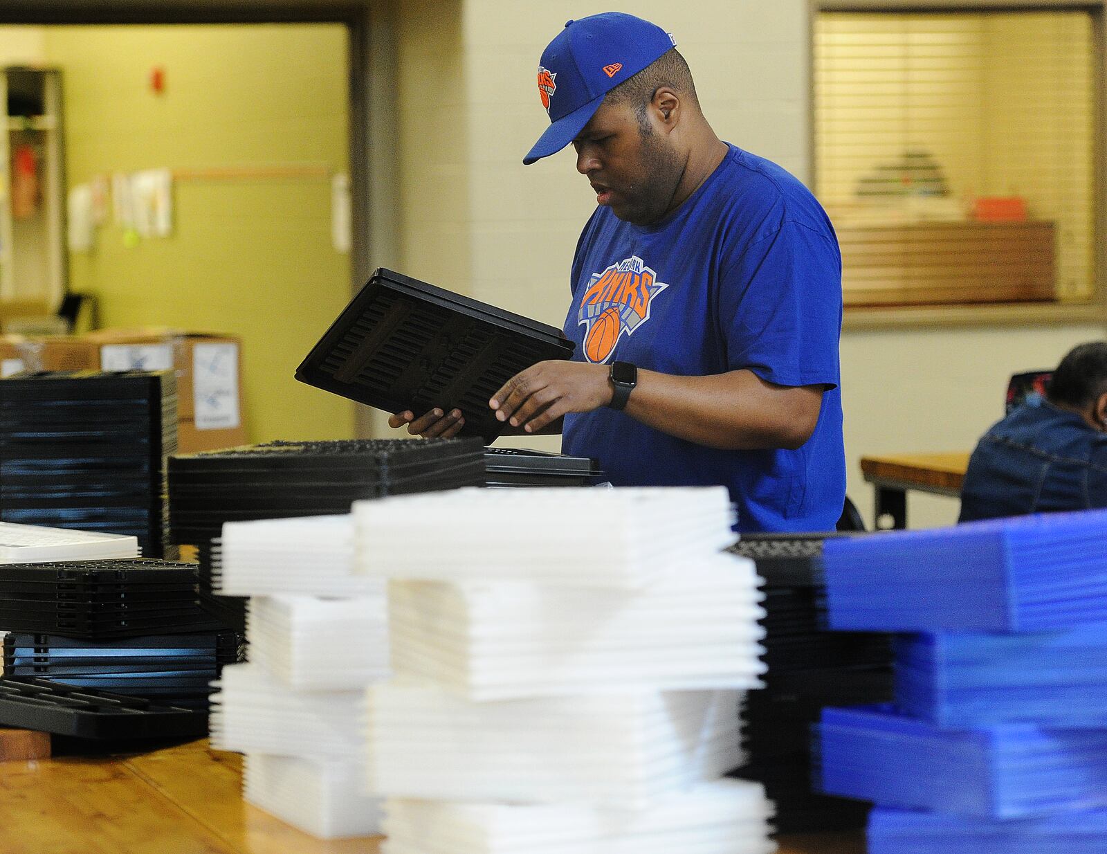 Jorge sorts through plastic trays for shipping, one of his tasks to earn a paycheck through the federal 14 c program. MARSHALL GORBY\STAFF