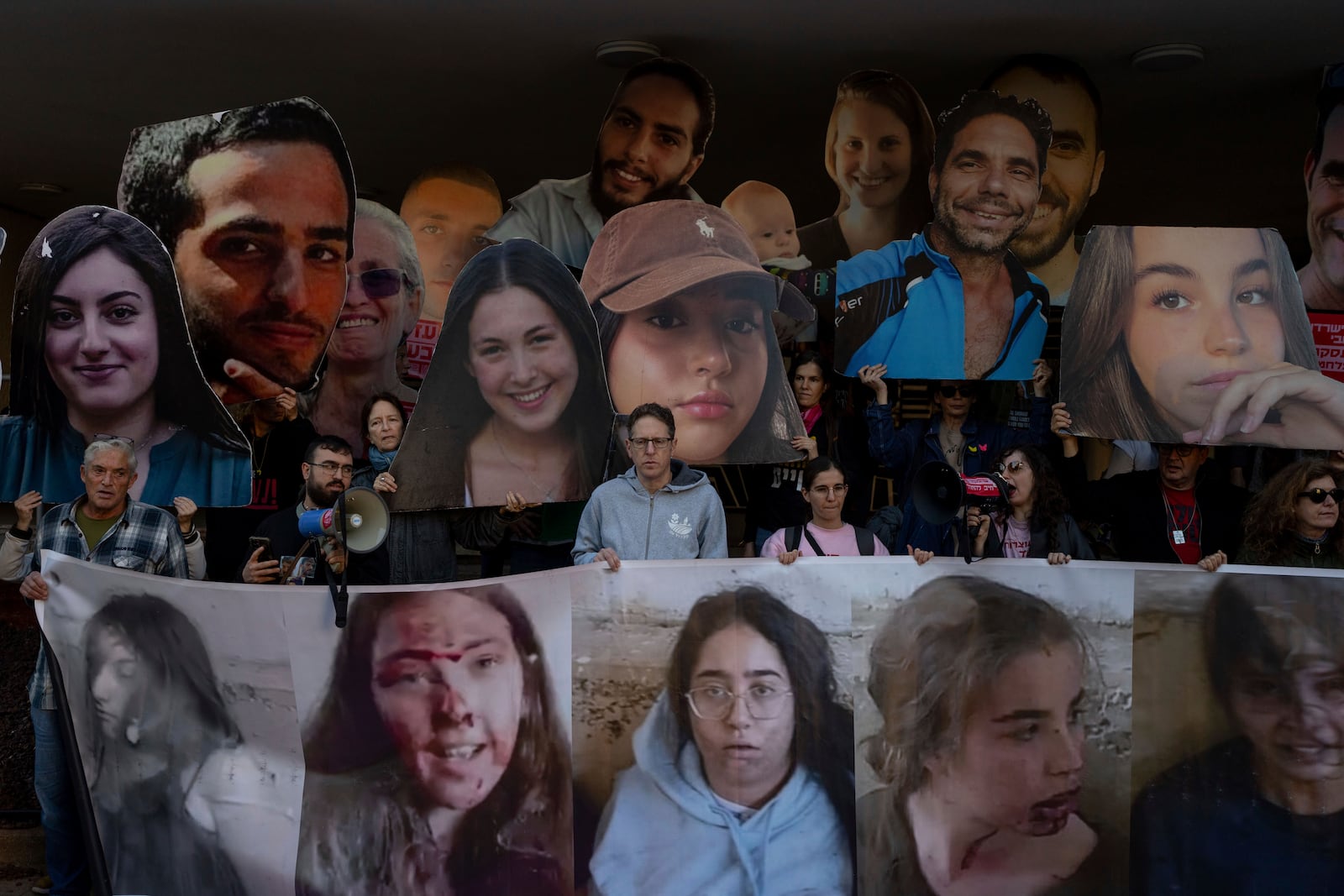 Relatives and supporters of Israeli hostages held by Hamas in Gaza hold photos of their loved ones during a protest calling for their return, in Tel Aviv, Israel, Wednesday, Jan. 8, 2025. (AP Photo/Ohad Zwigenberg)