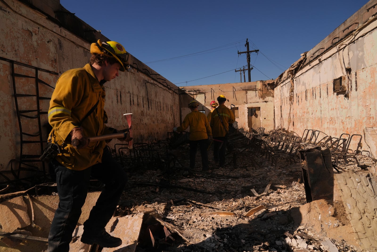 Search and rescue workers dig through the rubble left behind by the Eaton Fire, in Altadena, Calif., Tuesday, Jan. 14, 2025. (AP Photo/Jae C. Hong)