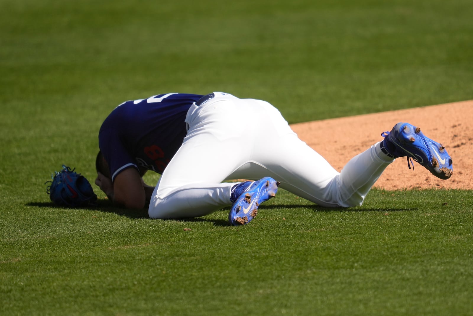 Los Angeles Dodgers pitcher Bobby Miller reacts after being hit by a line drive from Chicago Cubs' Michael Busch during the third inning of a spring training baseball game, Thursday, Feb. 20, 2025, in Phoenix. (AP Photo/Ashley Landis)