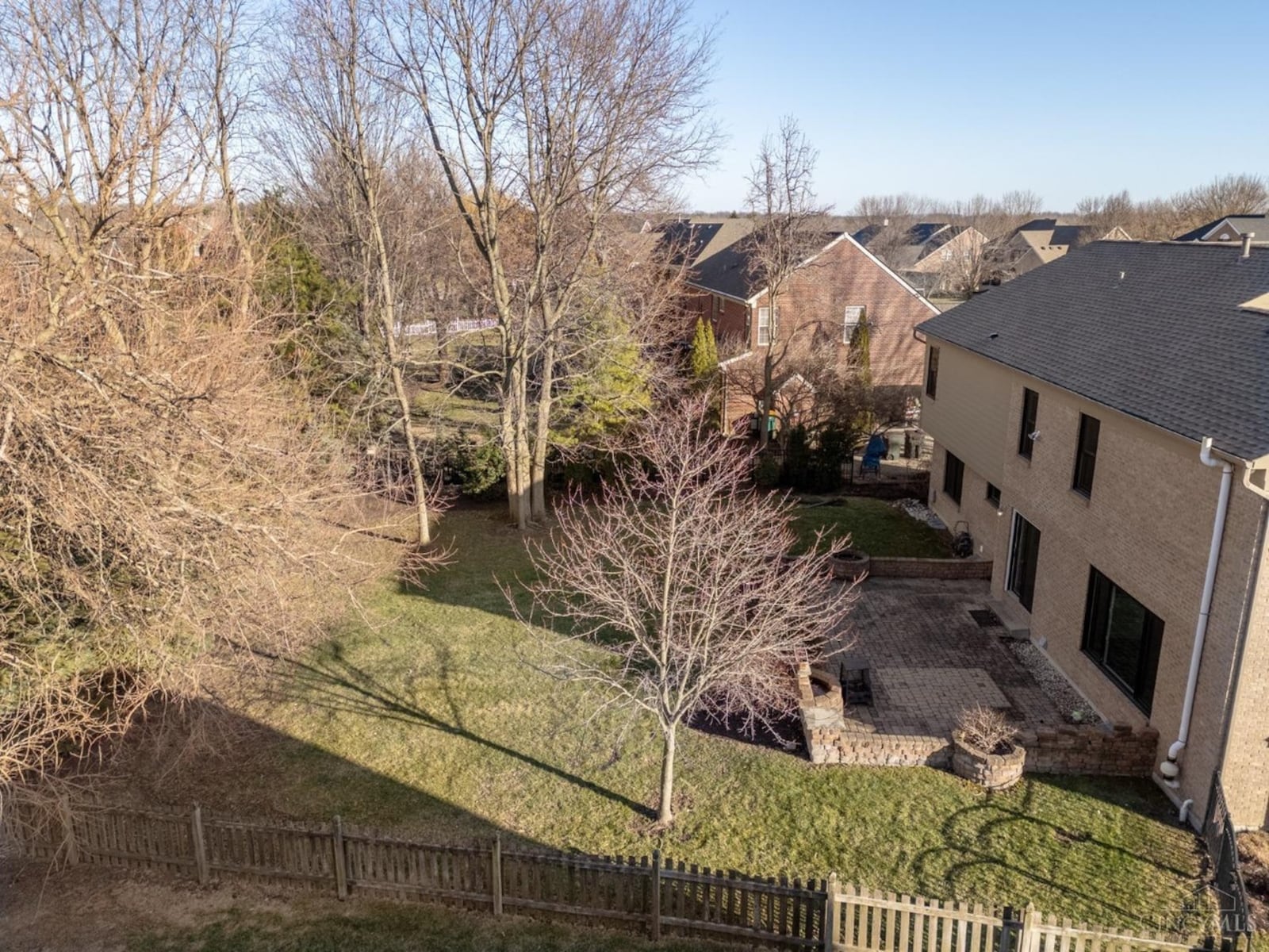 The backyard is partially fenced and has a brick paver patio with half walls and built i planters.