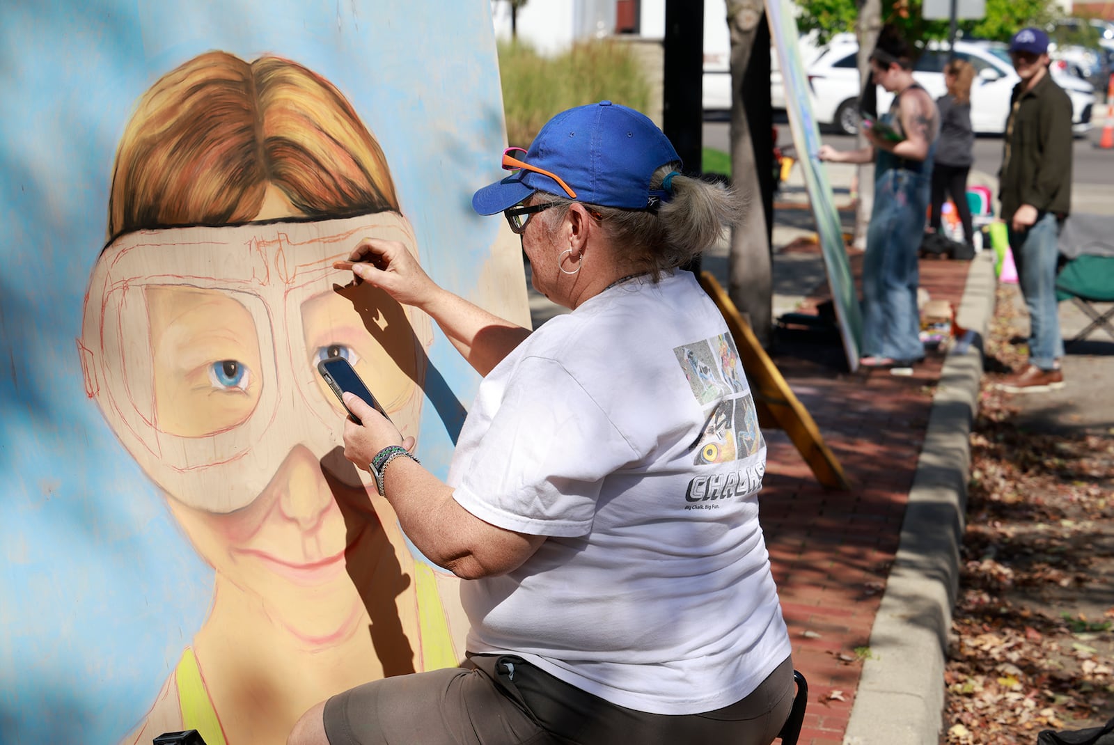 Sheryl Lazenby works on her chalk art Saturday, Oct. 5, 2024 during ChalkFest at National Road Commons Park in downtown Springfield. Dozens of amateur and professional artists from around the area showed off their skill on the sidewalks and streets around the park. ChalkFest also featured live music, food trucks and creative activities for the kids. BILL LACKEY/STAFF