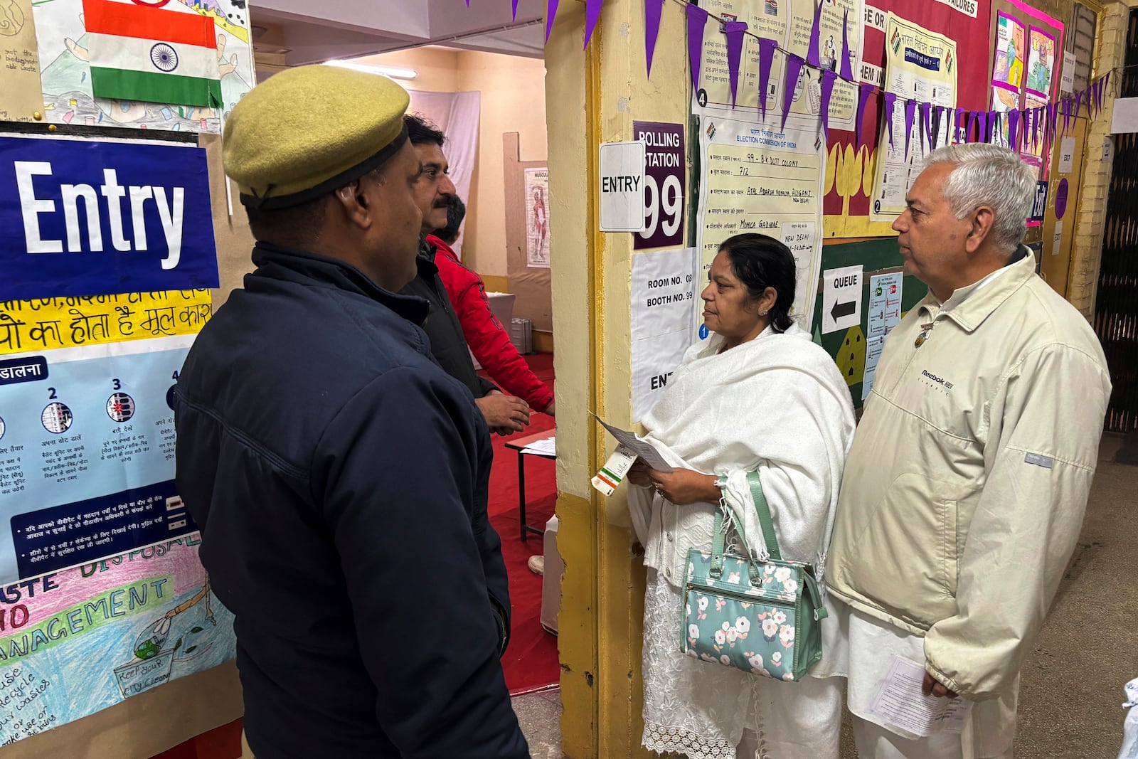 People stand in a queue to cast their votes for the capital’s state legislature election at a polling booth in New Delhi, India, Wednesday, Feb. 5, 2025. (AP Photo/Shonal Ganguly)