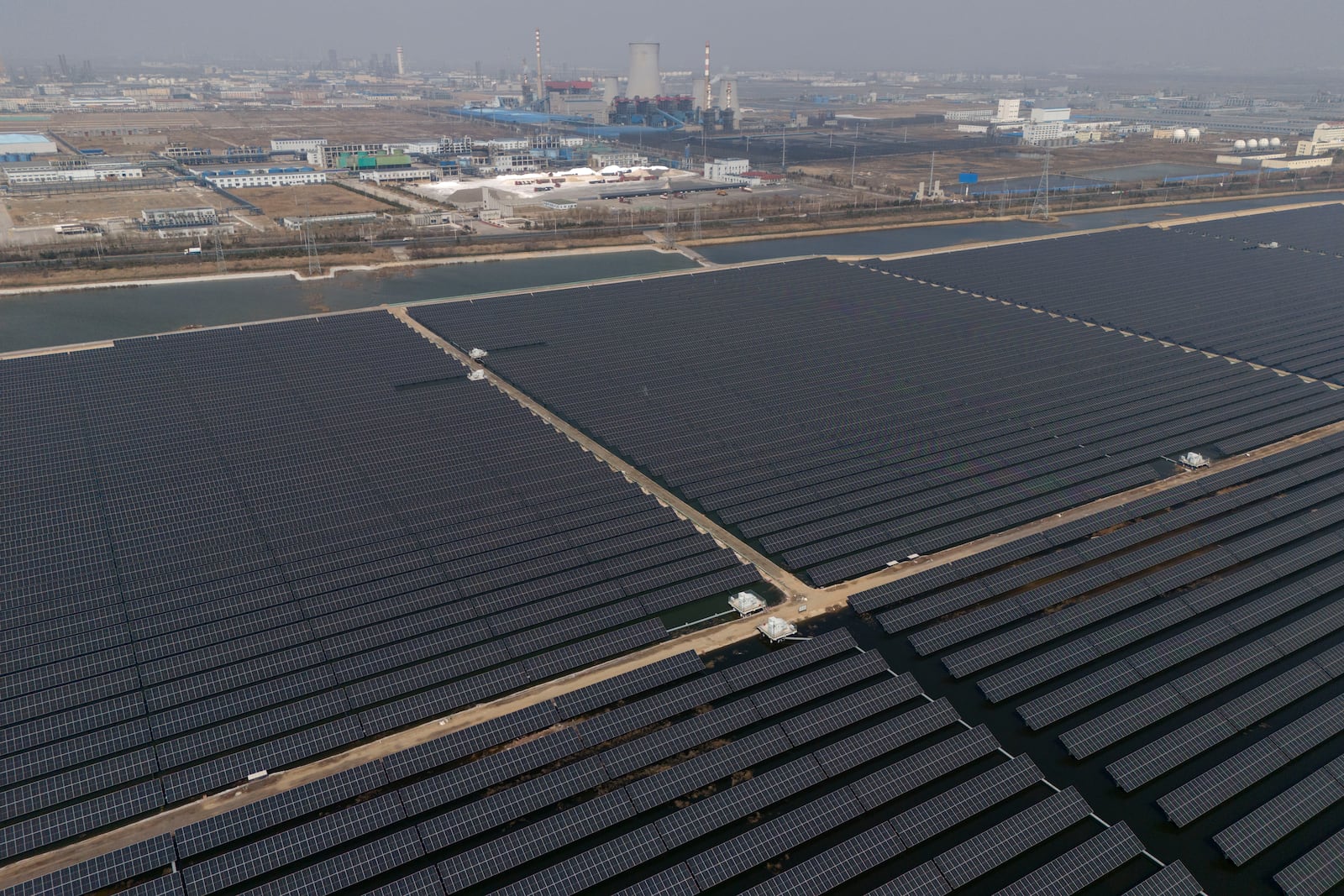 FILE - A solar farm operates near a chemical plant on the outskirts of Weifang in eastern China's Shandong province on March 22, 2024. (AP Photo/Ng Han Guan, File)