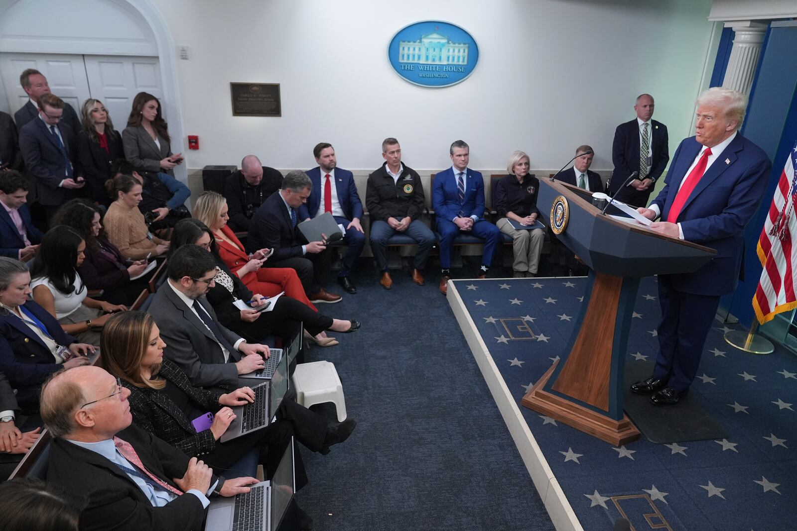 President Donald Trump speaks in the James Brady Press Briefing Room at the White House, Thursday, Jan. 30, 2025, in Washington. Seated against the wall are Vice President JD Vance, Transportation Secretary Sean Duffy and Secretary of Defense Pete Hegseth. (AP Photo/Jacquelyn Martin)