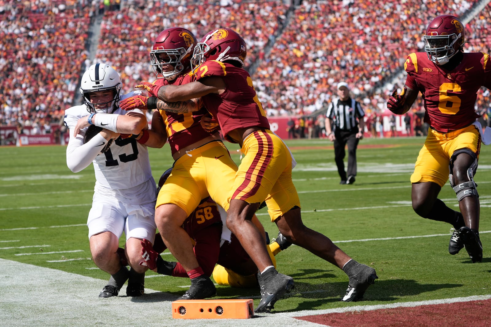 Penn State quarterback Drew Allar (15) is tackled out of bounds by two Southern California defenders during the first half of an NCAA college football game Saturday, Oct. 12, 2024, in Los Angeles. (AP Photo/Marcio Jose Sanchez)