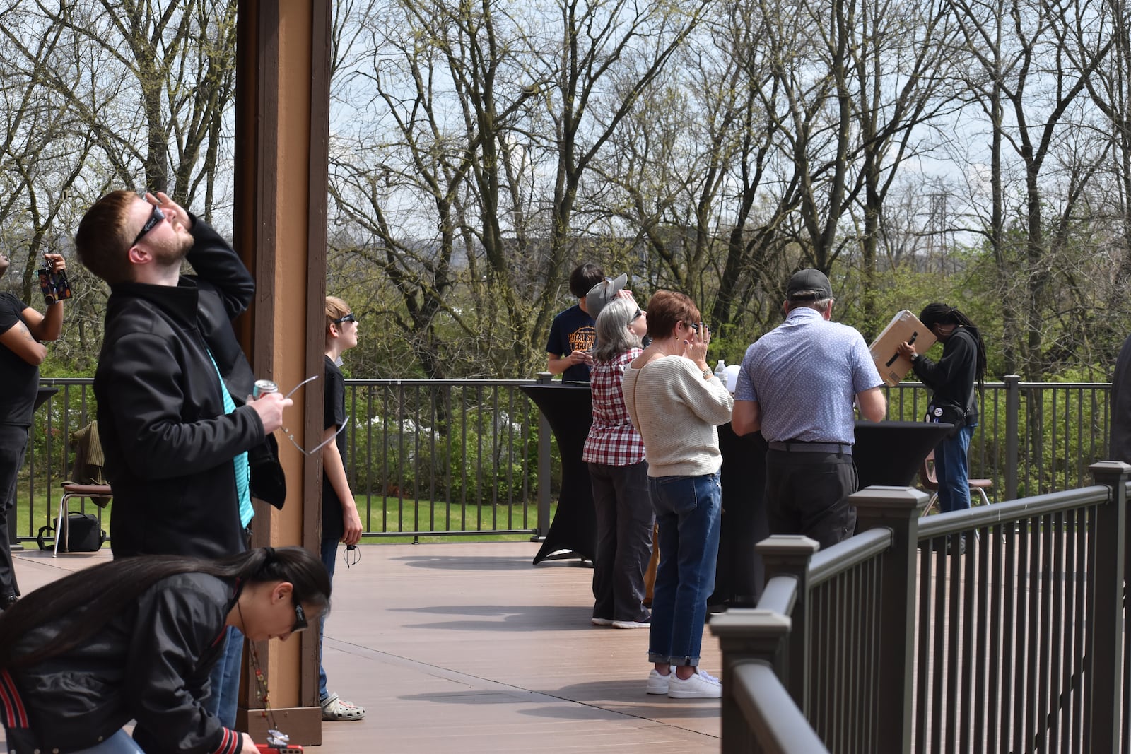 Viewers watch the eclipse with solar eclipse glasses and other devices at SunWatch Village in Dayton on Monday, April 8, 2024. SAMANTHA WILDOW\STAFF