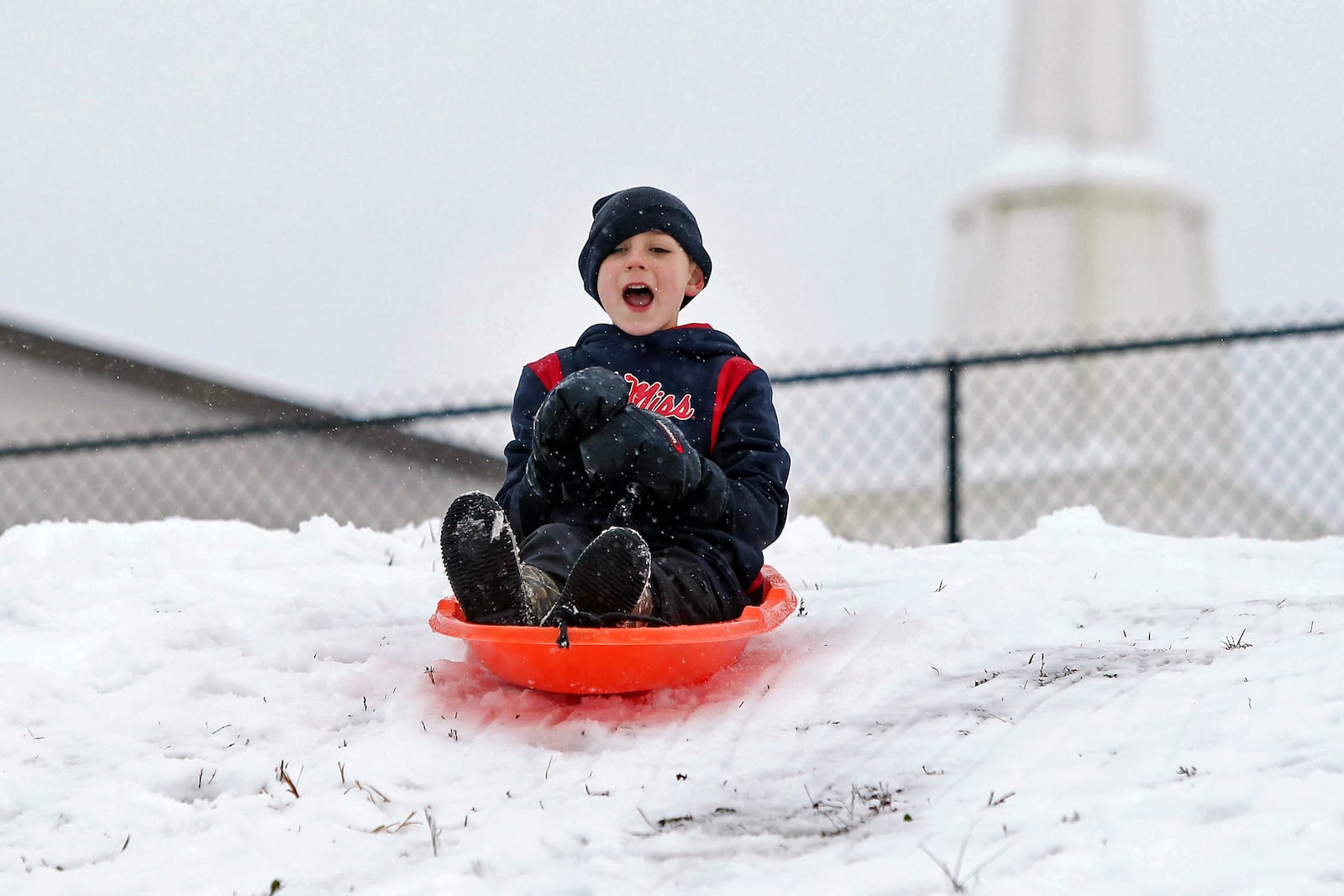 Nathan Bremseth, 8 of Tupelo, shouts out in excitement as he sleds down the hill in the snow at St. Luke United Methodist Church, Friday, Jan. 10, 2025, in Tupelo, Miss. (Adam Robison/The Northeast Mississippi Daily Journal via AP)