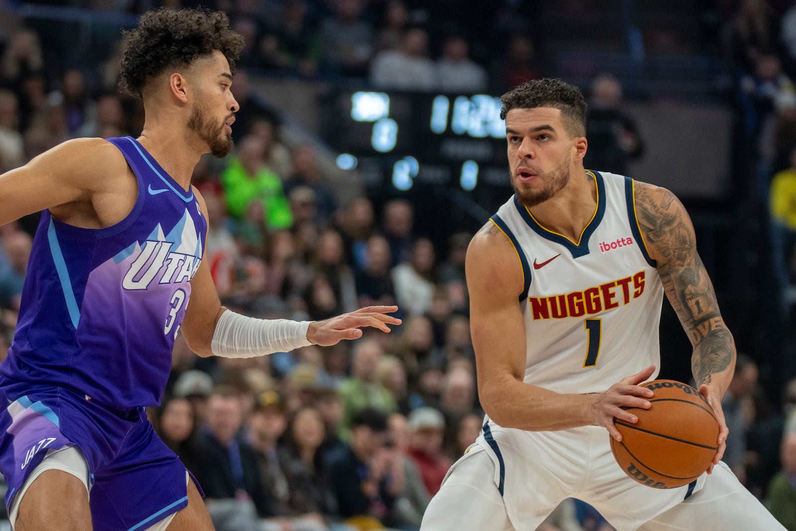 Denver Nuggets forward Michael Porter Jr. (1) looks to shoot as Utah Jazz guard Johnny Juzang, left, defends during the first half of an NBA basketball game Monday, Dec. 30, 2024, in Salt Lake City. (AP Photo/Rick Egan)