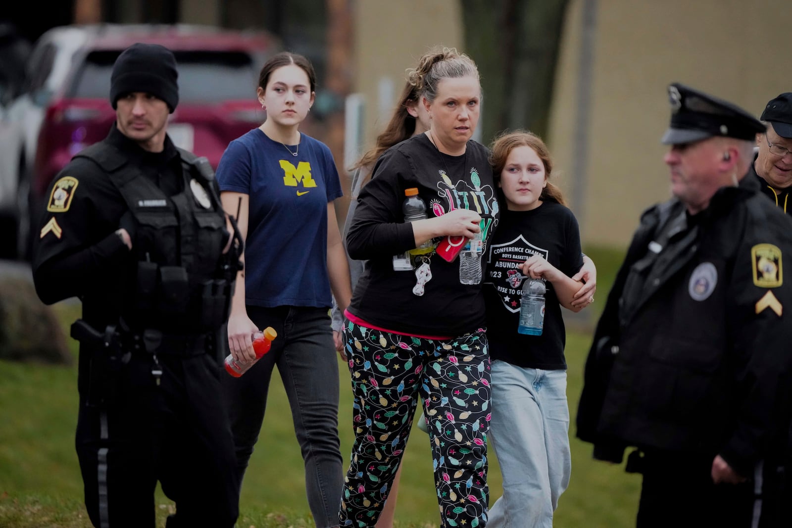 A family leave the shelter after multiple injuries were reported following a shooting at the Abundant Life Christian School, Monday, Dec. 16, 2024. (AP Photo/Morry Gash)