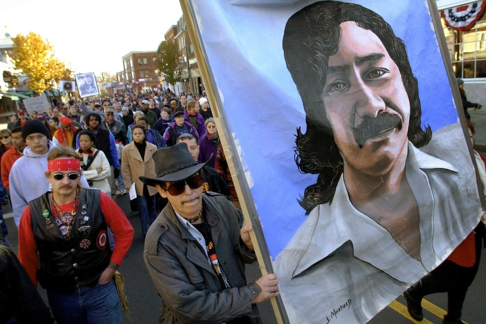 FILE - Marchers carry a large painting of jailed American Indian Leonard Peltier during a march on the National Day of Mourning in Plymouth, Mass., Nov. 22, 2001. (AP Photo/Steven Senne, File)