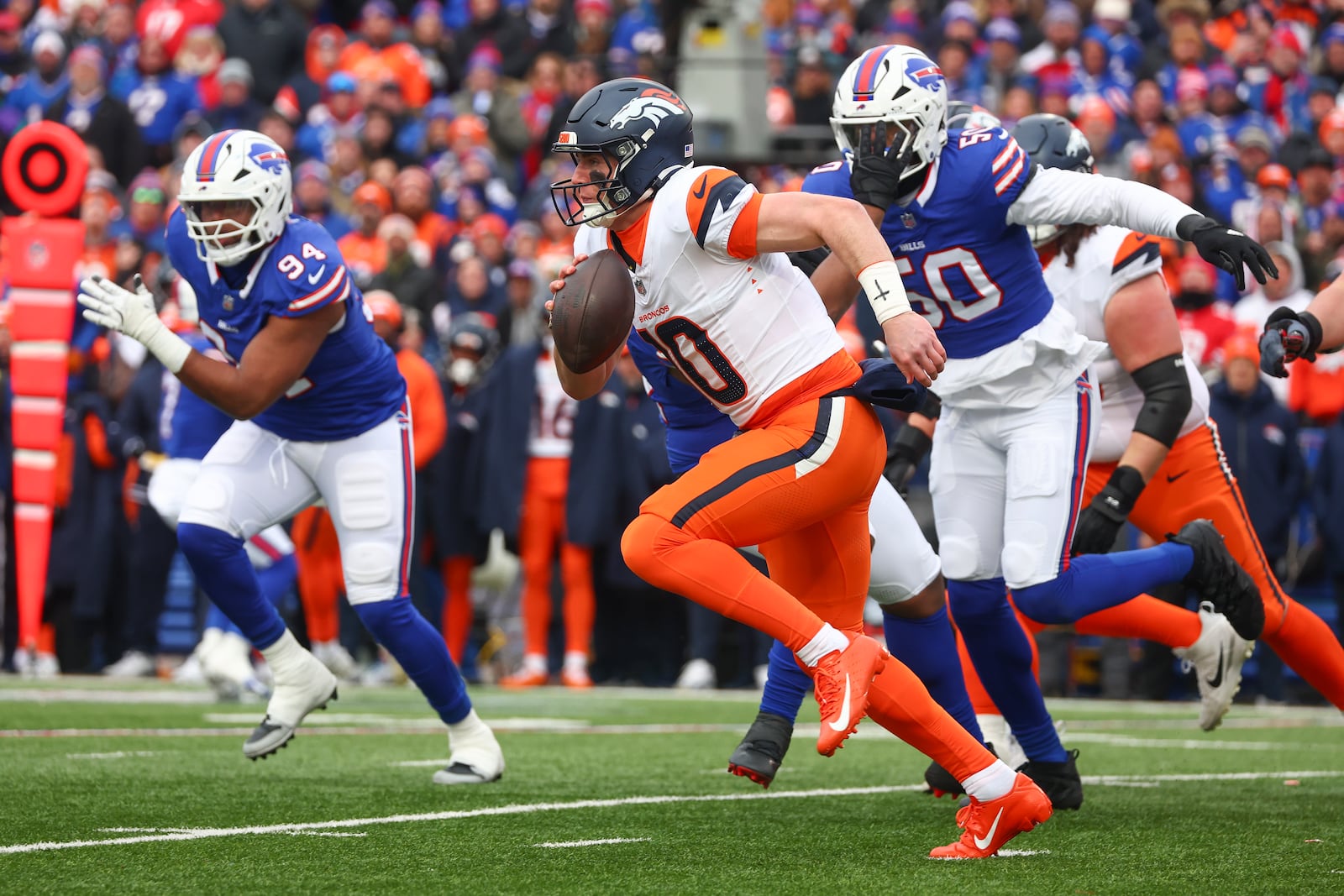 Denver Broncos quarterback Bo Nix (10) scrambles for a first down against the Buffalo Bills during the second quarter of an NFL wild card playoff football game, Sunday, Jan. 12, 2025, in Orchard Park, N.Y. (AP Photo/Jeffrey T. Barnes)