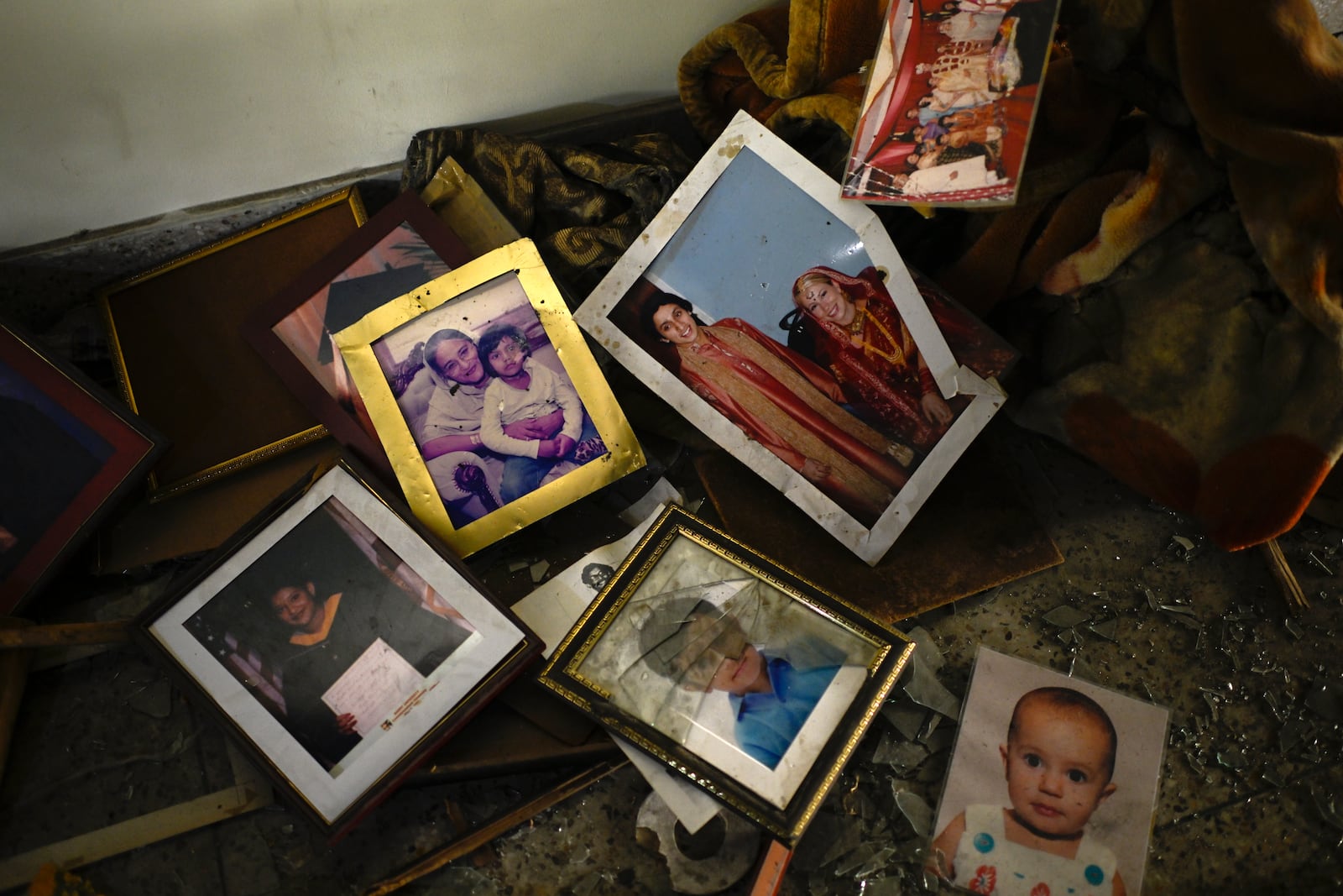 Family photographs on the floor in a room of the vandalized residence of Bangladesh's ousted Prime Minister Sheikh Hasina, in Dhaka, Bangladesh, Thursday, Feb. 6, 2025. (AP Photo/Mahmud Hossain Opu)