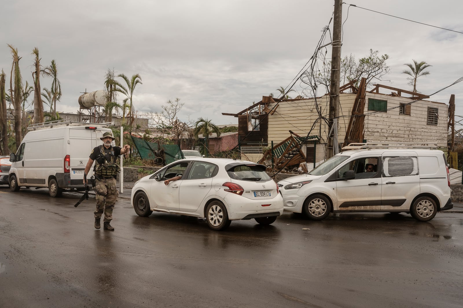 A French officer directs traffic for essential vehicles, in Mamoudzou, Mayotte, Thursday, Dec. 19, 2024. (AP Photo/Adrienne Surprenant)