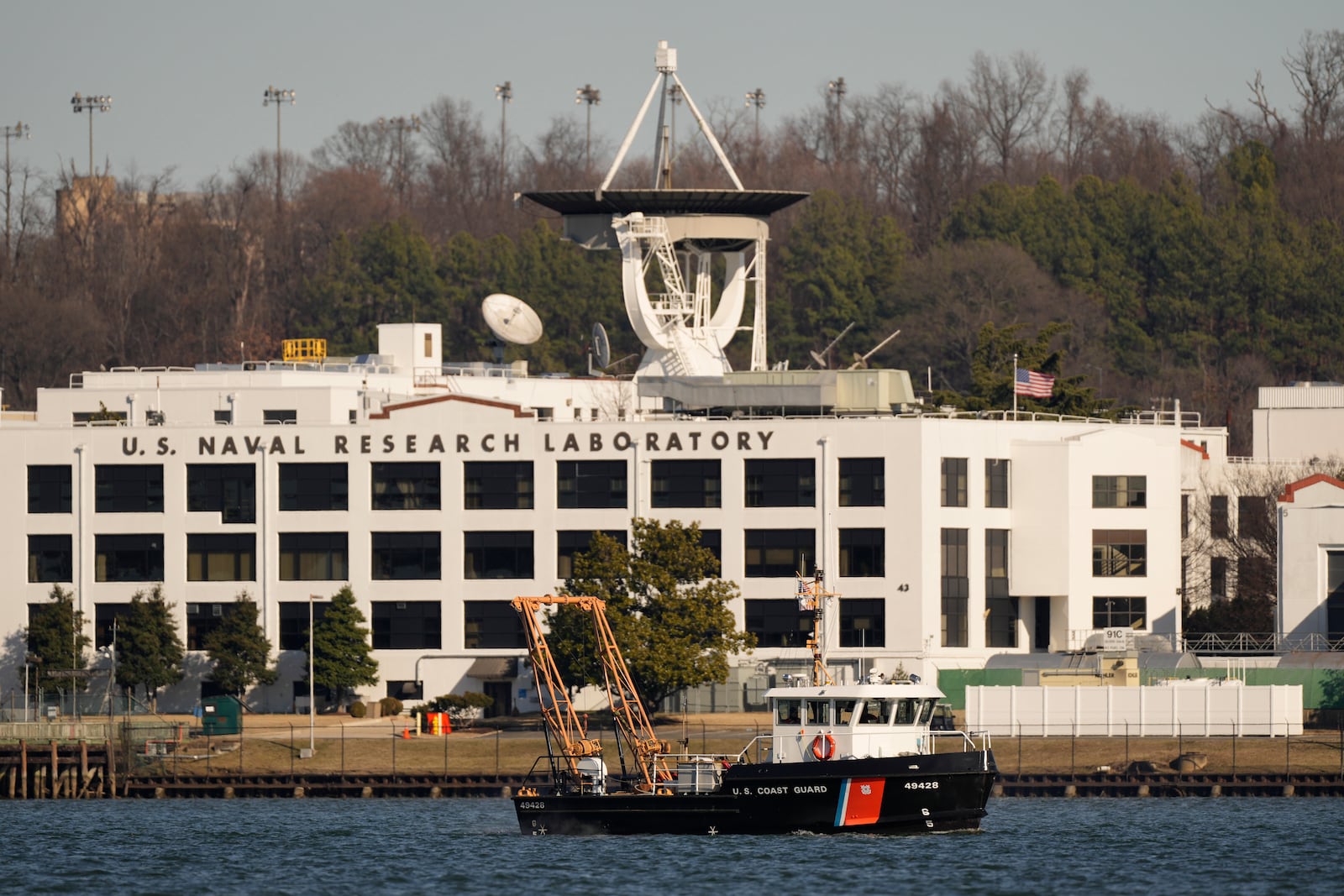 A Coast Guard vessel works on the Potomac river, Saturday, Feb. 1, 2025, in Arlington, Va., near the wreckage site where an American Airlines jet and a Black Hawk helicopter collided, as seen from Alexandria, Va. (AP Photo/Carolyn Kaster)