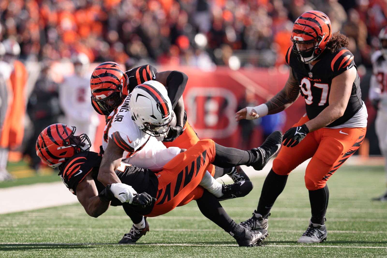 Cincinnati Bengals linebacker Maema Njongmeta, left, makes a tackle with safety Jordan Battle (27) on Cleveland Browns running back Pierre Strong Jr. (20) during the first half of an NFL football game, Sunday, Dec. 22, 2024, in Cincinnati. (AP Photo/Jeff Dean)