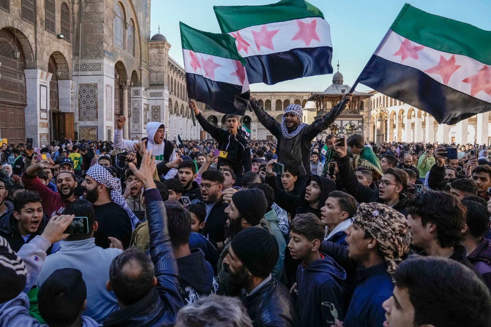 FILE - People chant slogans and wave the new Syrian flag as they gather for Friday prayers at the Umayyad mosque in Damascus, Syria, on Dec. 13, 2024. (AP Photo/Leo Correa, File)