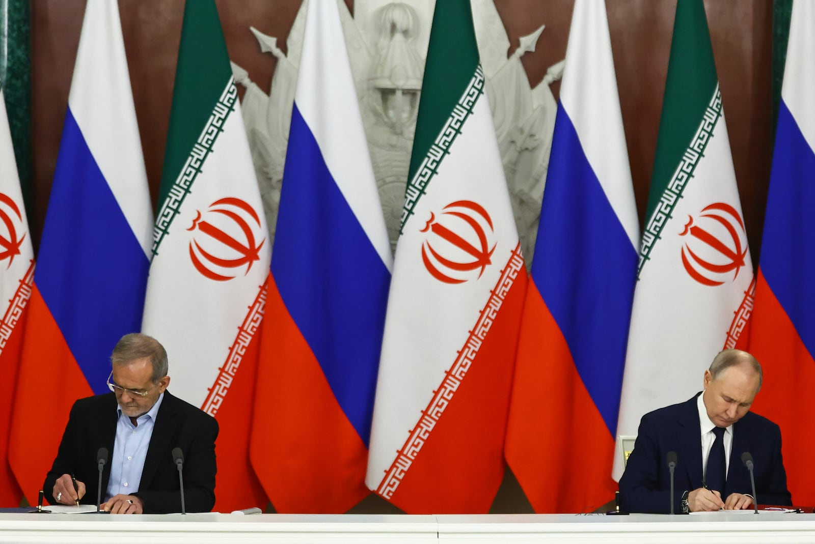 Russian President Vladimir Putin, right, and Iranian President Masoud Pezeshkian attend a signing ceremony at the Kremlin in Moscow, Russia, Friday, Jan. 17, 2025. (Evgenia Novozhenina/Pool Photo via AP)