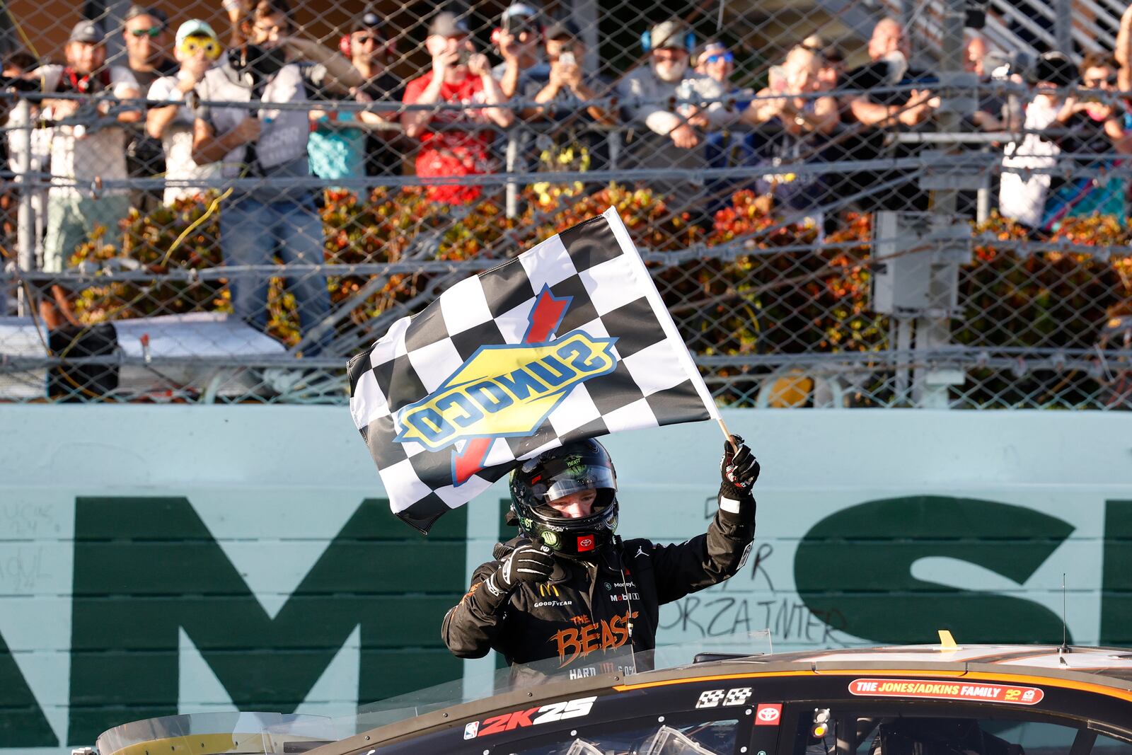 Tyler Reddick celebrates with the checkered flag at the finish line after winning a NASCAR Cup Series auto race at Homestead-Miami Speedway in Homestead, Fla., Sunday, Oct. 27, 2024. (AP Photo/Terry Renna)