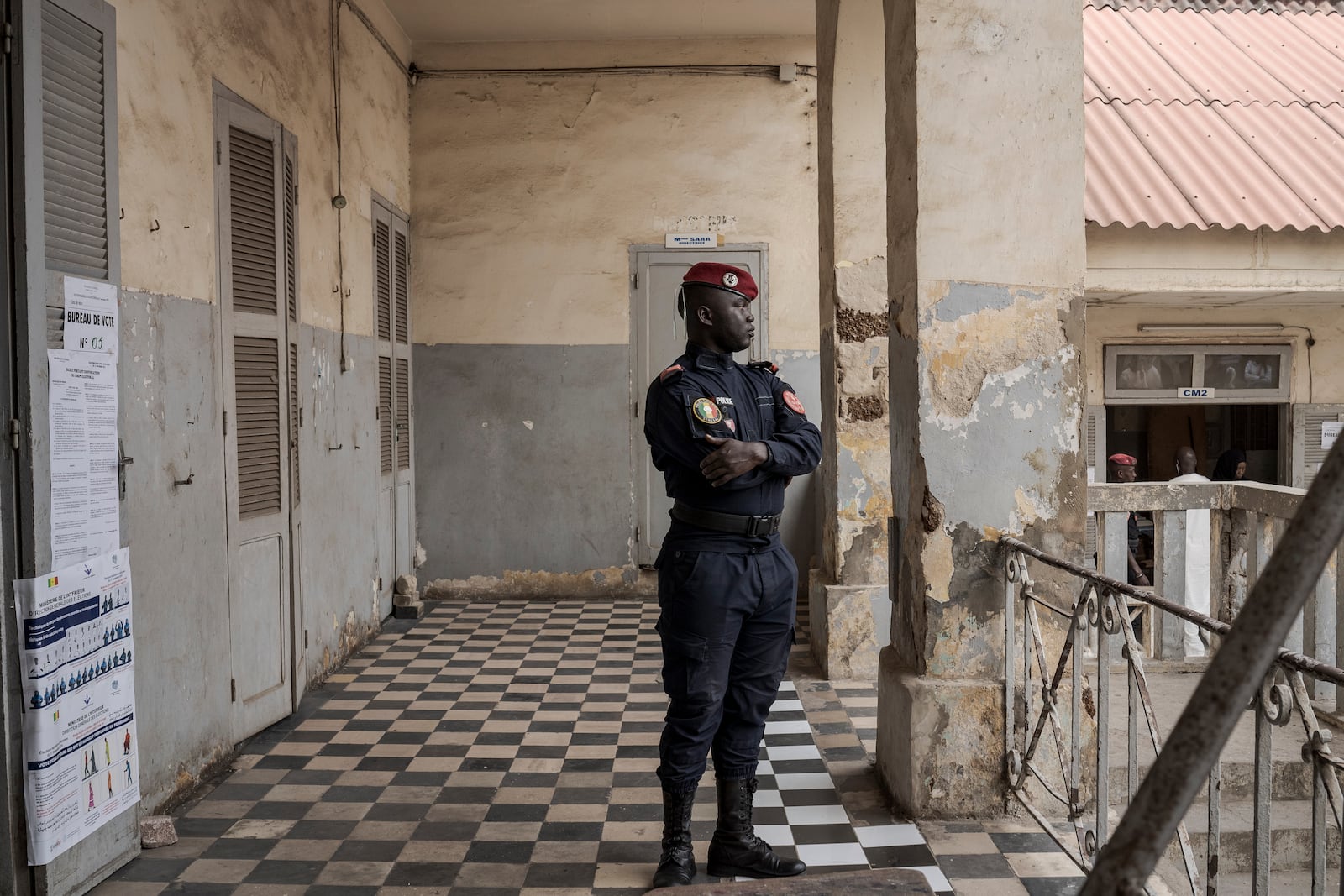 A member of security forces stands guard as people wait to cast their votes outside a polling station during the legislative elections in Dakar, Senegal Sunday, Nov. 17, 2024. (AP Photo/Annika Hammerschlag)