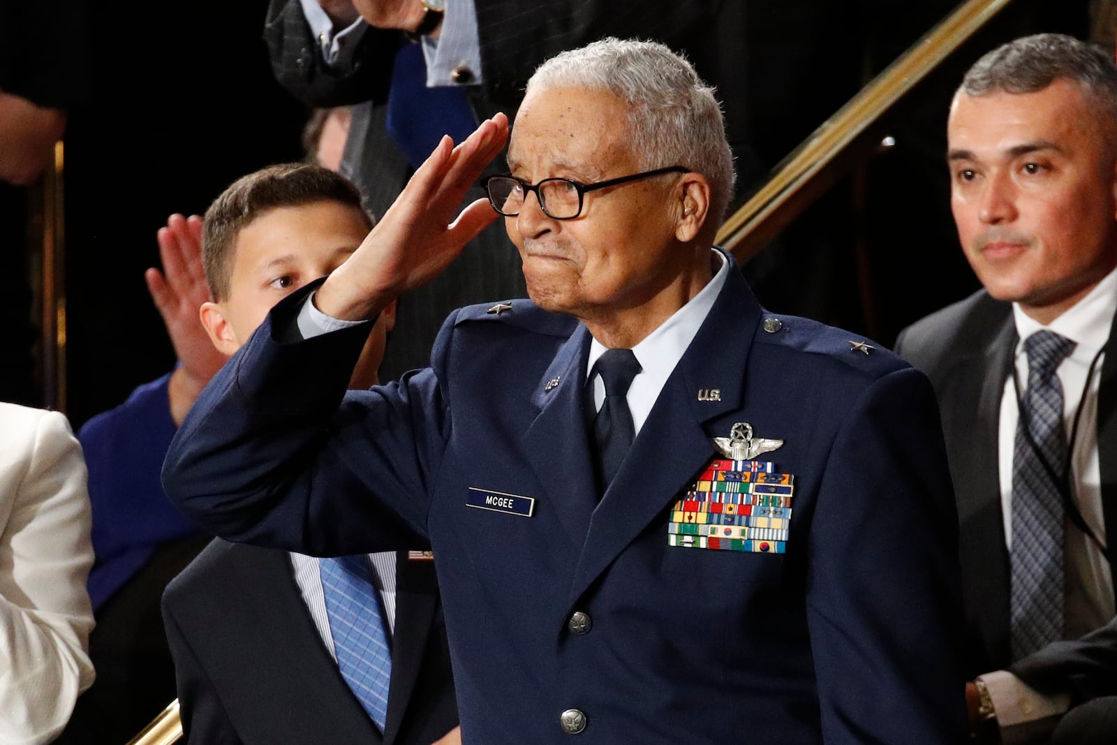 FILE - Tuskegee airman Charles McGee salutes as his great grandson Iain Lanphier, left, looks on as President Donald Trump delivers his State of the Union address to a joint session of Congress on Capitol Hill in Washington, Feb. 4, 2020. (AP Photo/Patrick Semansky, File)