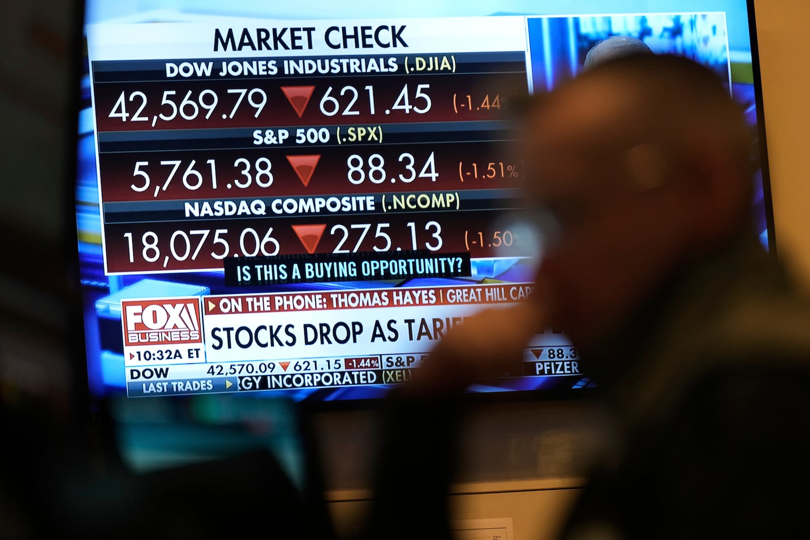 Financial news is displayed as people work on the floor at the New York Stock Exchange in New York, Tuesday, March 4, 2025. (AP Photo/Seth Wenig)