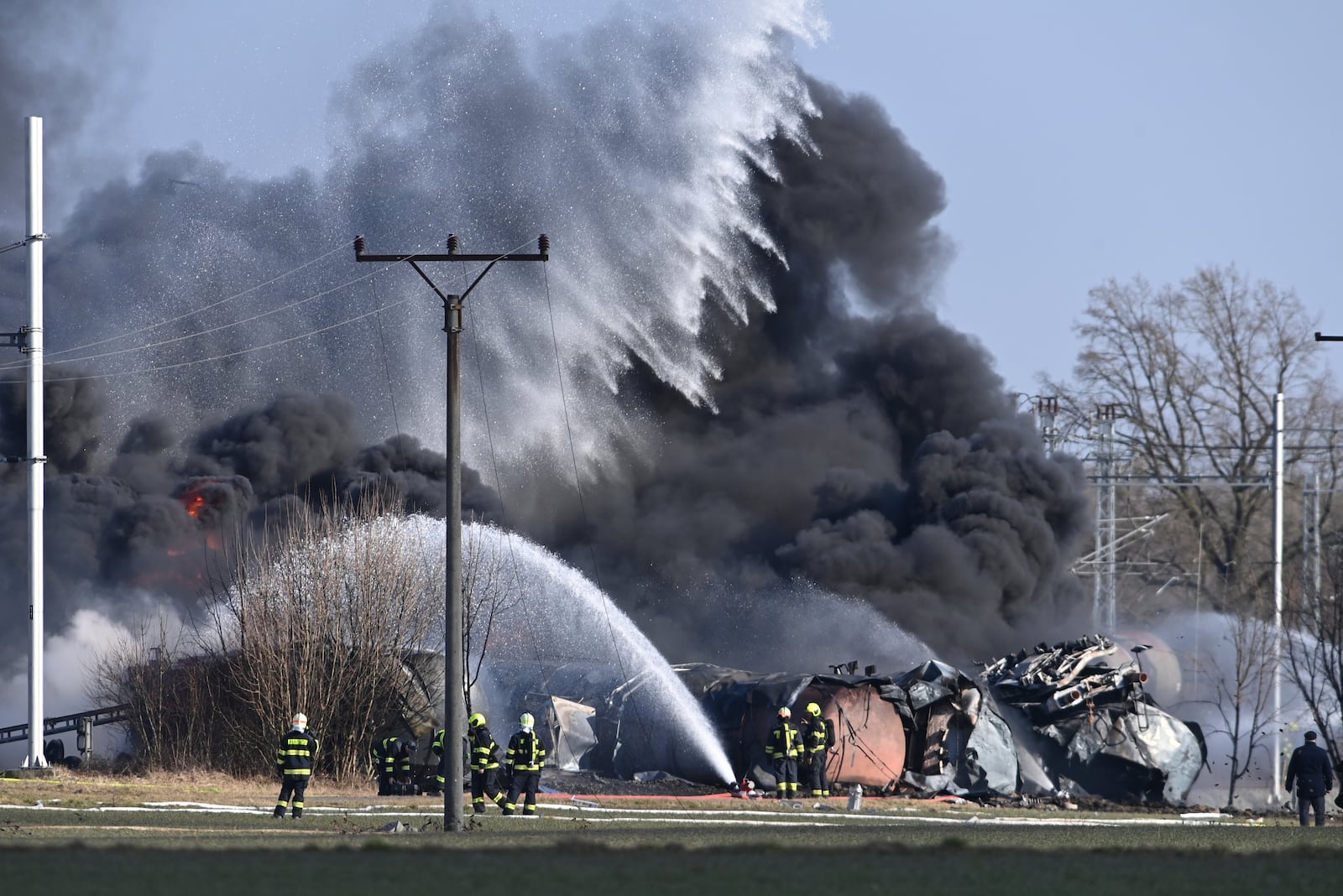 Firefighters battle a large fire of a derailed freight train carrying benzene, a highly flammable and toxic liquid, Friday, Feb. 28, 2025, in Hustopece nad Becvou, Czech Republic,. (Ludek Perina/CTK via AP)