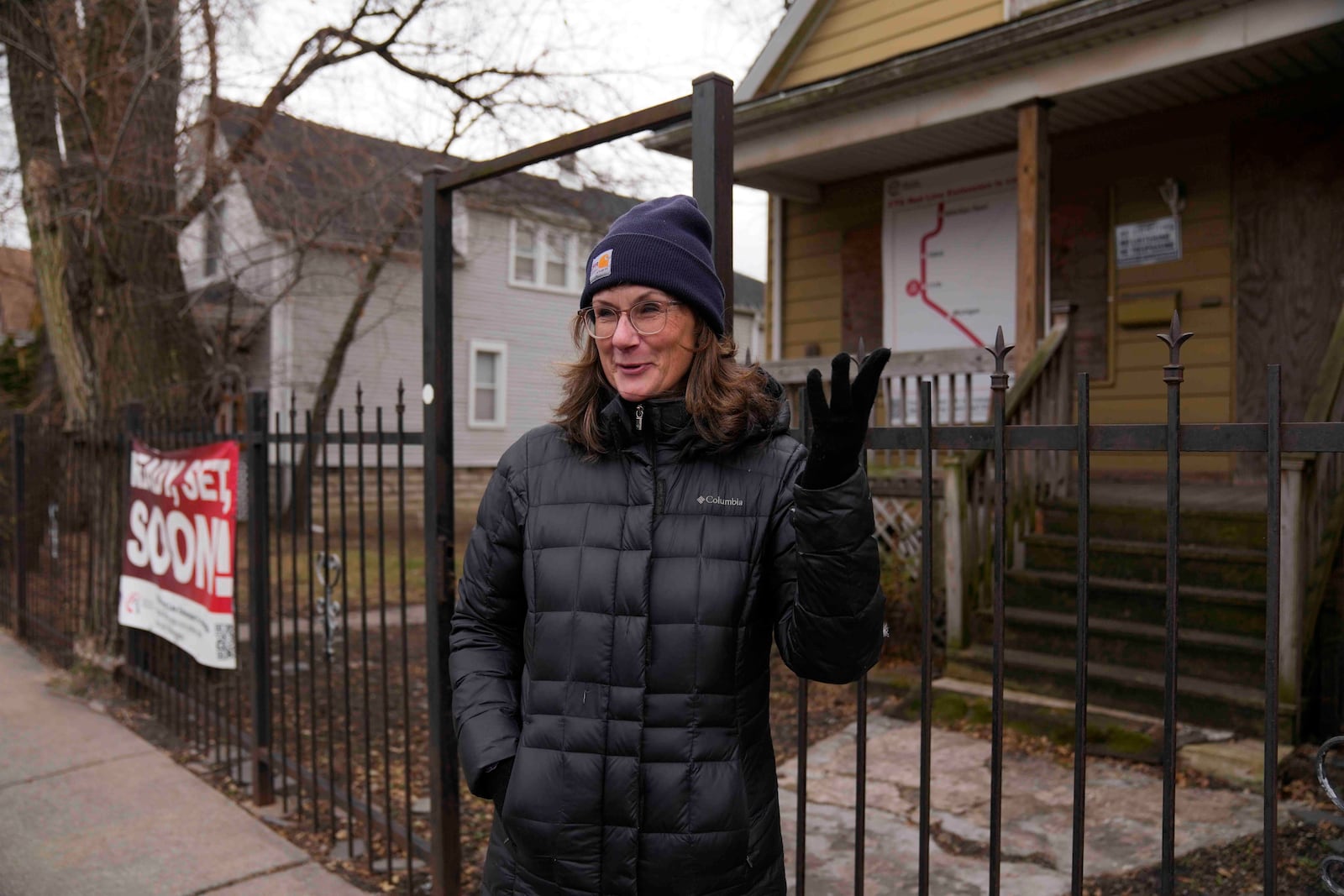 Chicago Transit Authority spokesperson Tammy Chase talks about the expansion of the Red Line train route in front of a boarded-up property set for demolition to make room for a new train station on West 111th Street, Wednesday, Dec. 11, 2024, in the Roseland neighborhood of Chicago. (AP Photo/Erin Hooley)