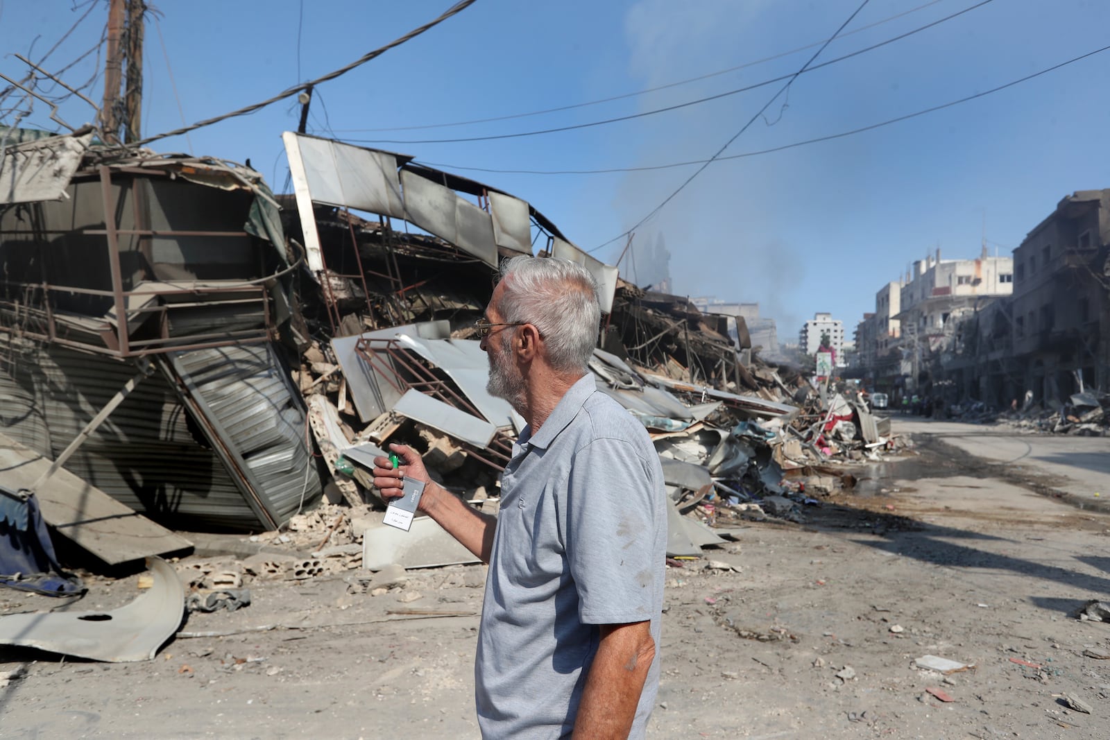 Lebanese man Ahmad Fakih checks his destroyed coffeeshop at a commercial street that was hit Saturday night by Israeli airstrikes, in Nabatiyeh town, south Lebanon, Sunday, Oct. 13, 2024. (AP Photo/Mohammed Zaatari)