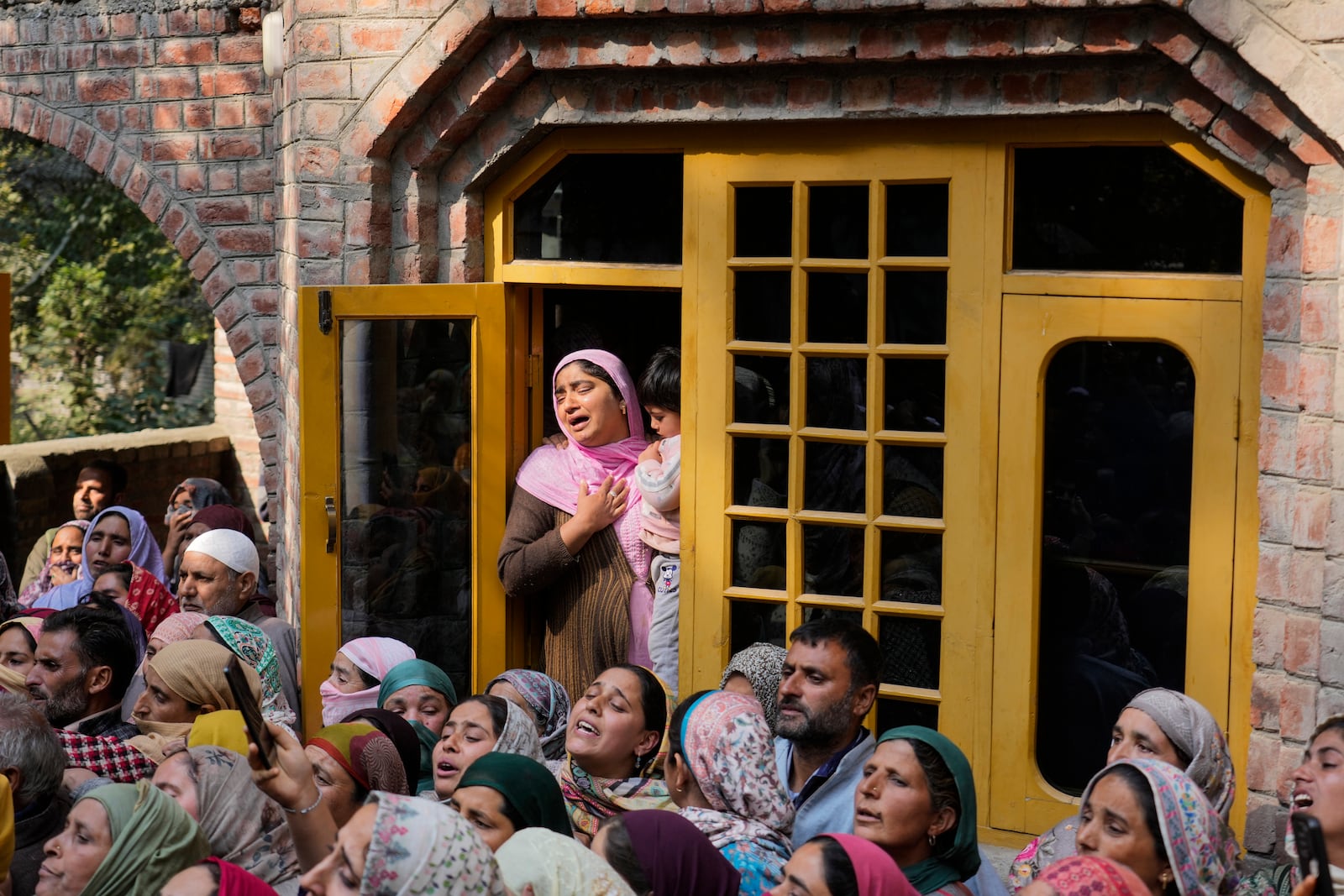 Relatives and neighbors cry as they watch the funeral of Kashmiri doctor Shahnawaz who was among those killed when gunmen fired at people working on a strategic tunnel project in Indian-controlled Kashmir, at Nadigam village, southwest of Srinagar, Monday, Oct. 21, 2024. (AP Photo/Mukhtar Khan)