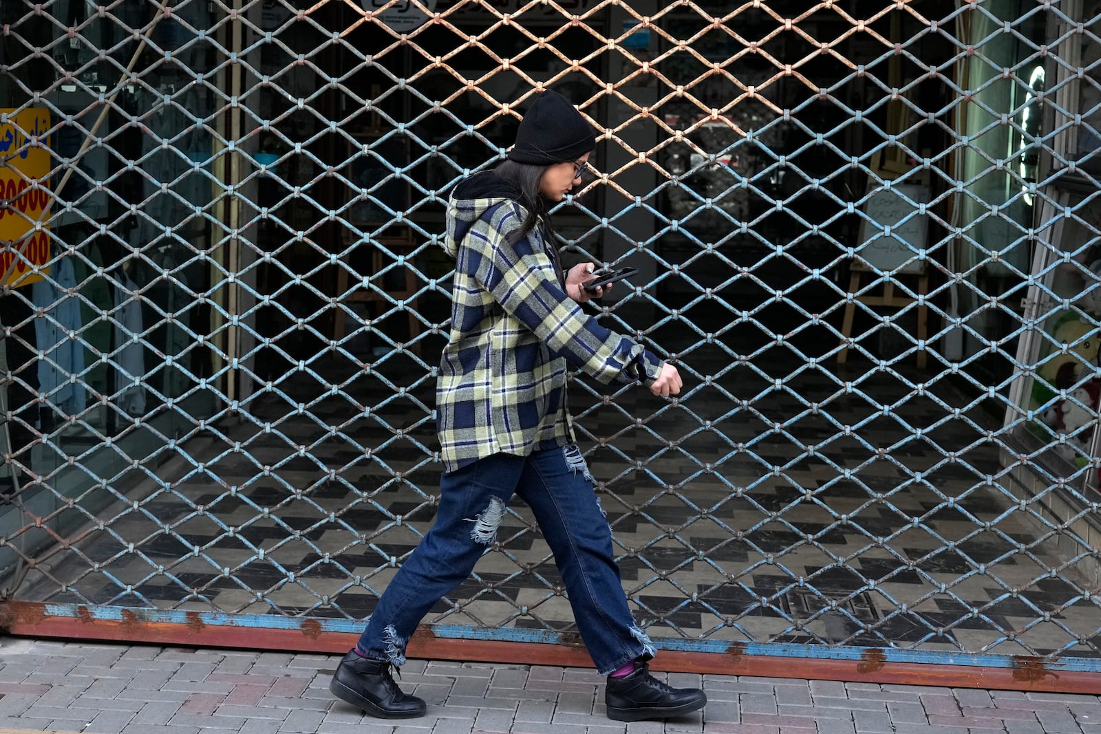 An Iranian woman walks in port city of Bandar Anzali in northern Iran, Thursday, Dec. 5, 2024. (AP Photo/Vahid Salemi)