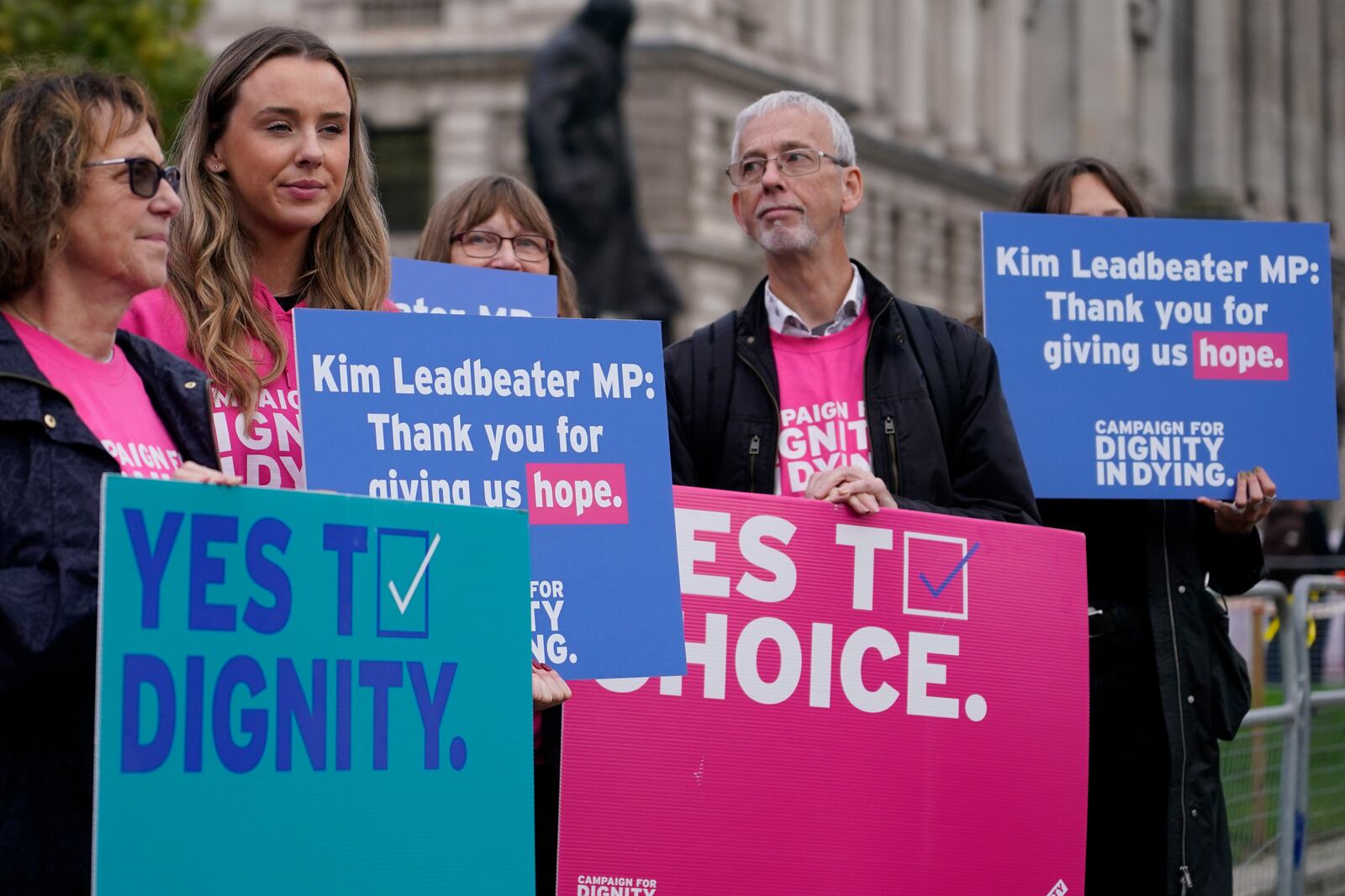 A small demonstration by people advocating assisted dying hold a protest outside the Hoses of Parliament as a bill to legalise assisted dying is to be put before lawmakers in London, England, Wednesday, Oct. 16, 2024. (AP Photo/Alberto Pezzali)